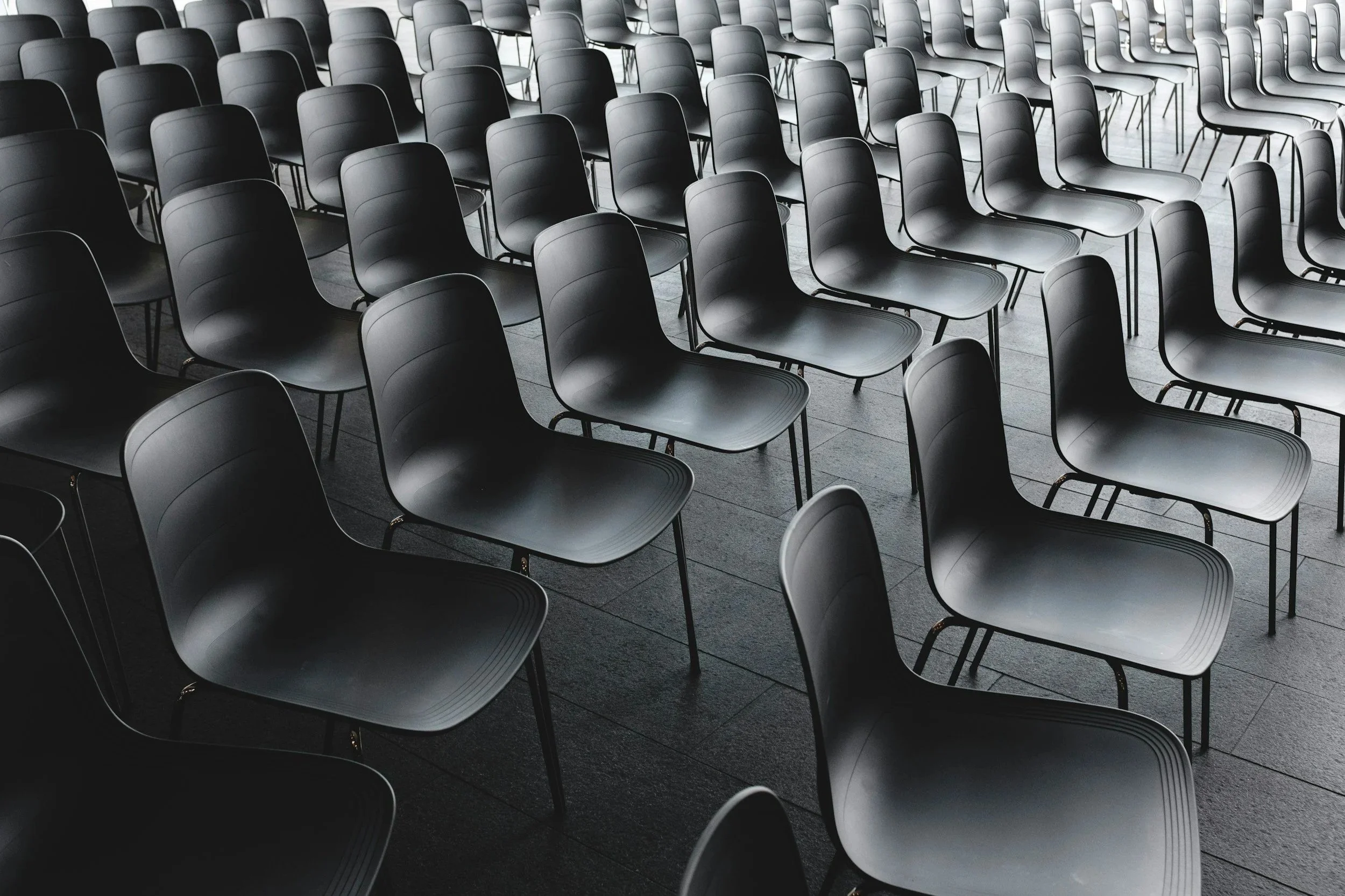 a black and white photo of chairs set up for a speaker event