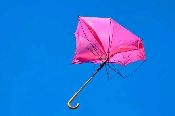 Inside out pink umbrella on a blue background