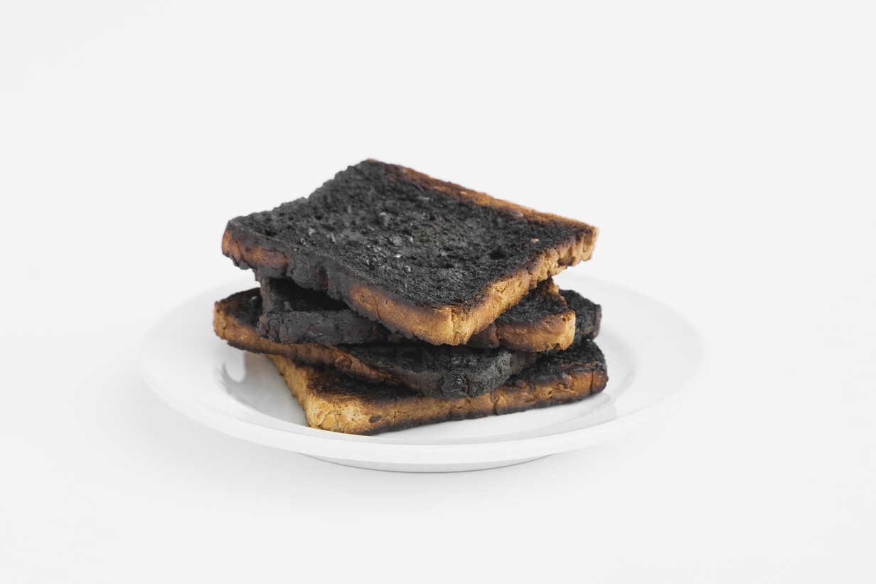 a stack of burned toast on a white plate