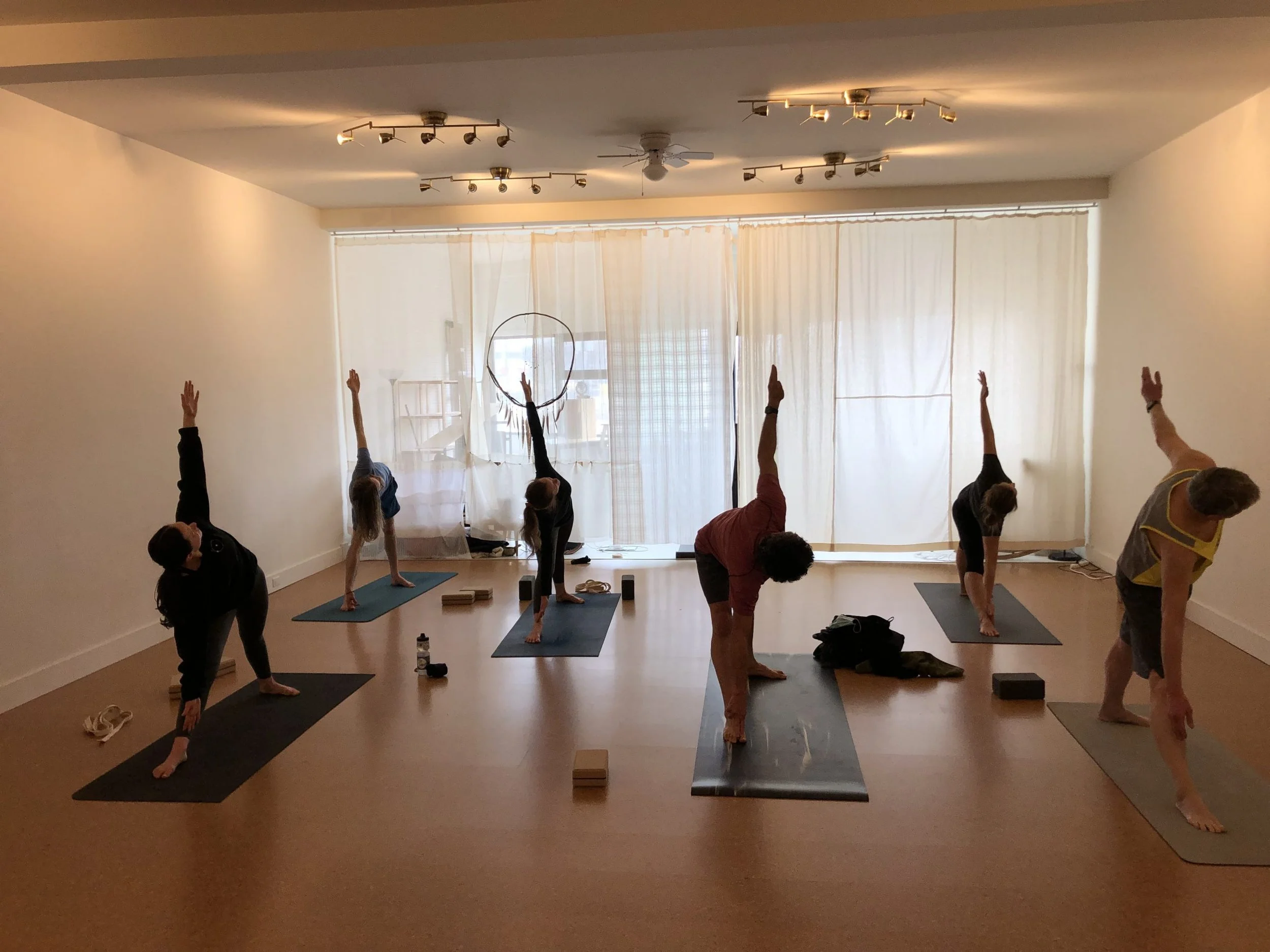 A class setting in Northern Flow Studio where students are practising the triangle pose