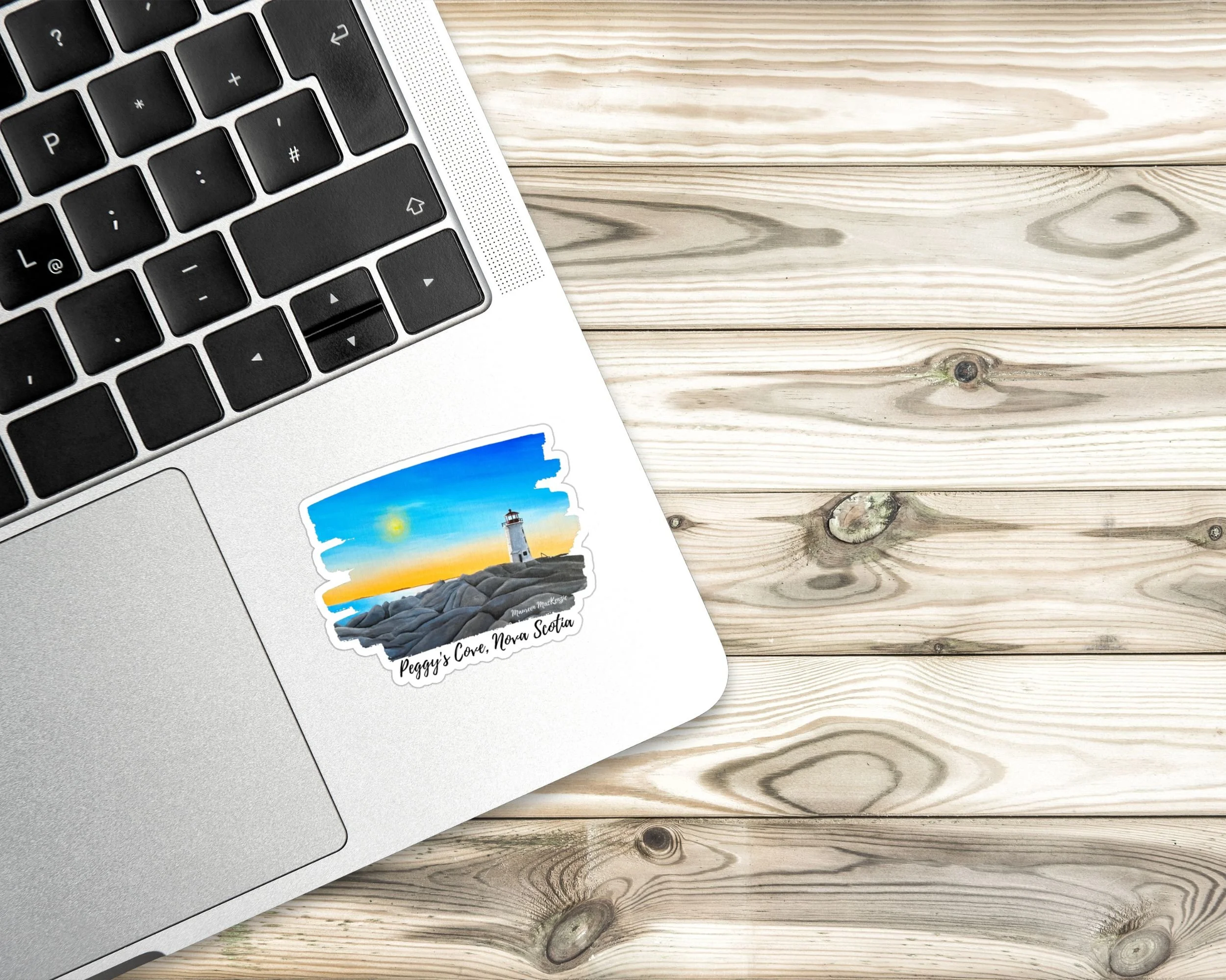 a unique nautical sticker of Peggy's Cove lighthouse at sunset in Halifax, Nova Scotia.  This reproduction of Maureen's acrylic painting is on a laptop