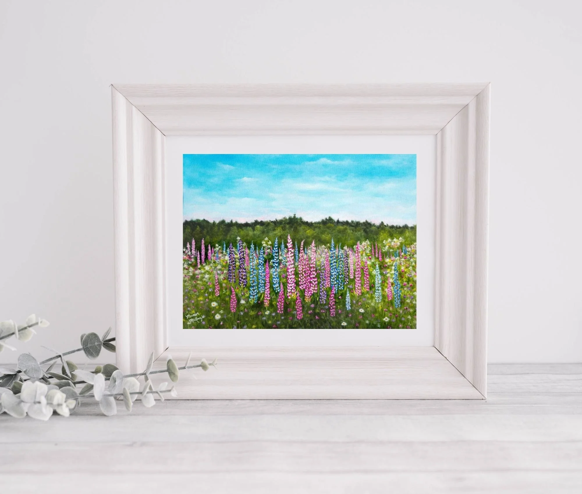 a framed print of a print of a colorful field of pink and purple lupines in bloom under a pale blue sky,