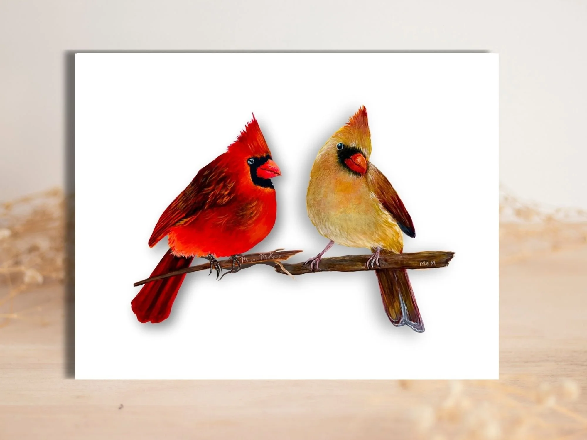 a greeting card of a male and female cardinal perched on a branch facing each other on a white background
