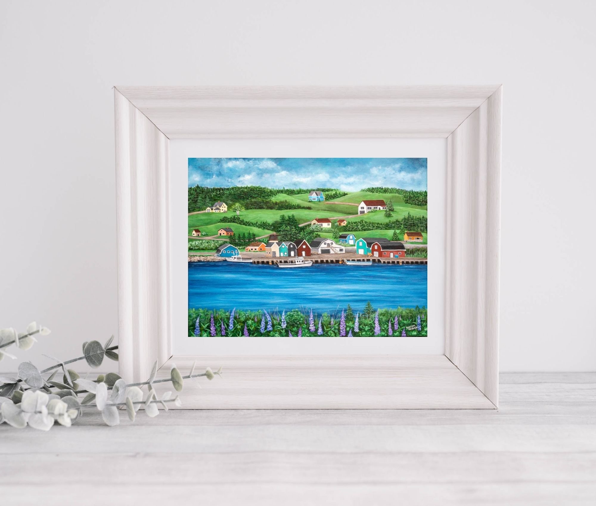 A giclée print of French River in Prince Edward Island featuring colorful fishing buildings along a wharf, blue water, green hills, and purple lupins in the foreground.