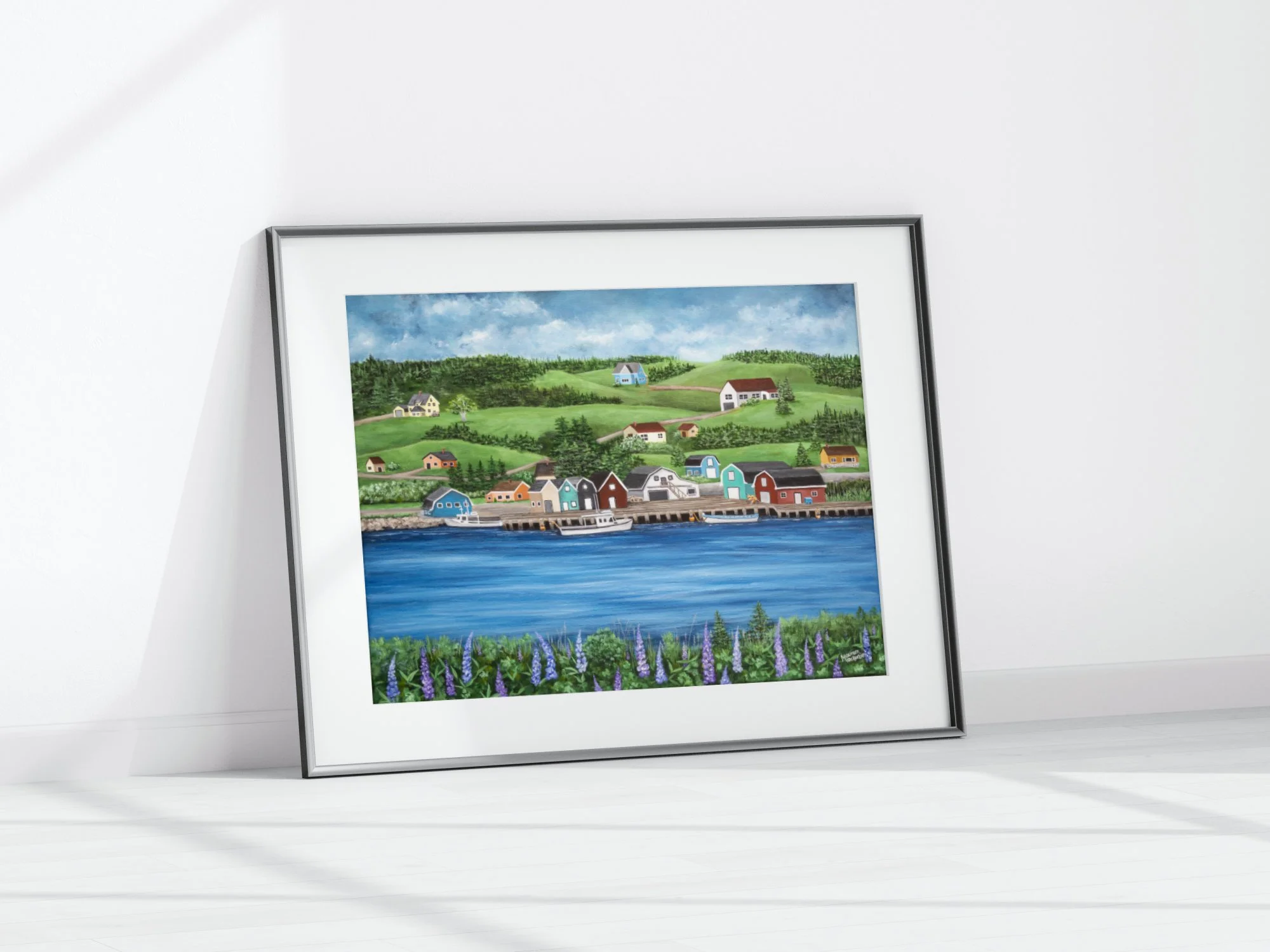 A giclée print of French River in Prince Edward Island featuring colorful fishing buildings along a wharf, blue water, green hills, and purple lupins in the foreground.