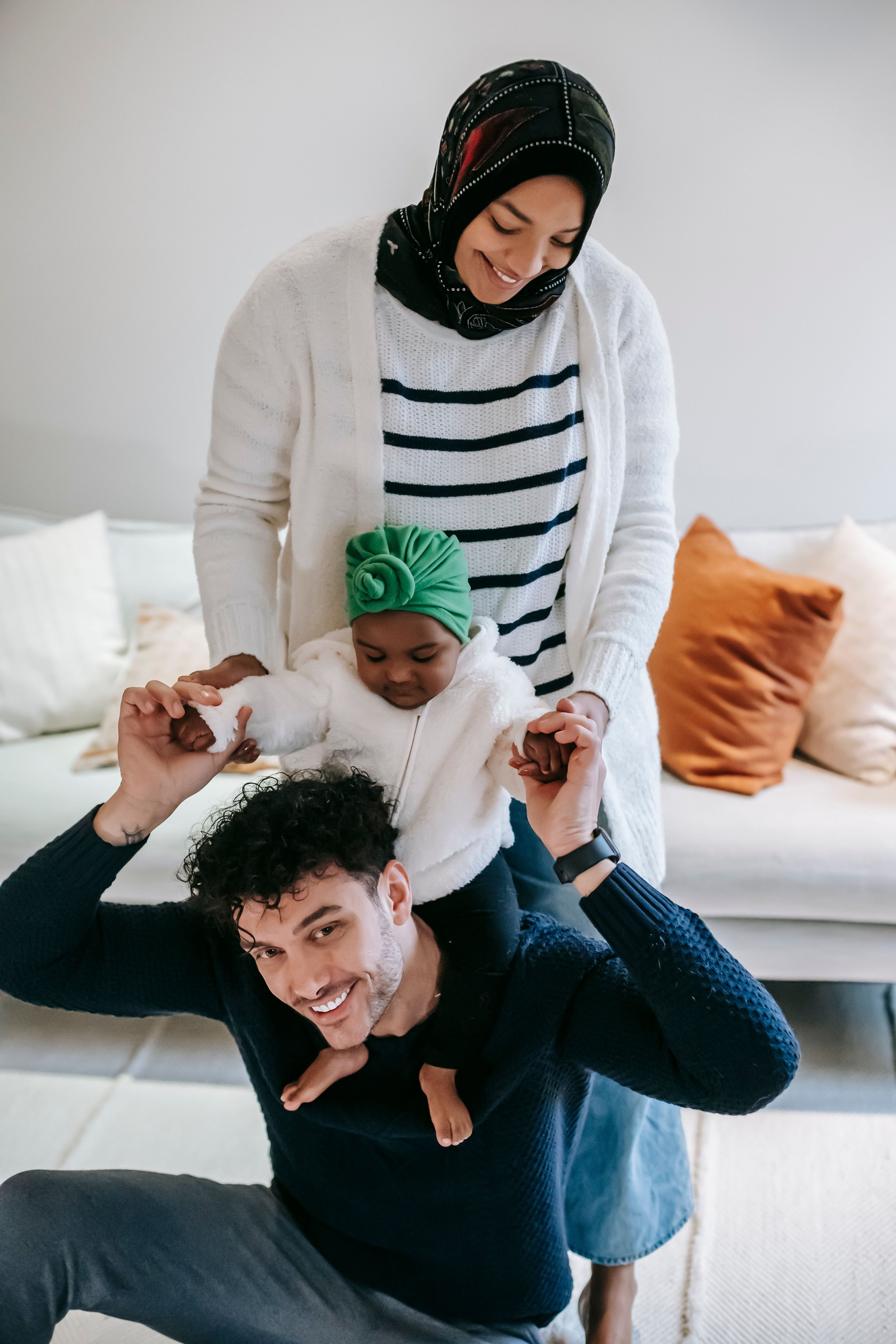 A mother and father smiling at their toddler