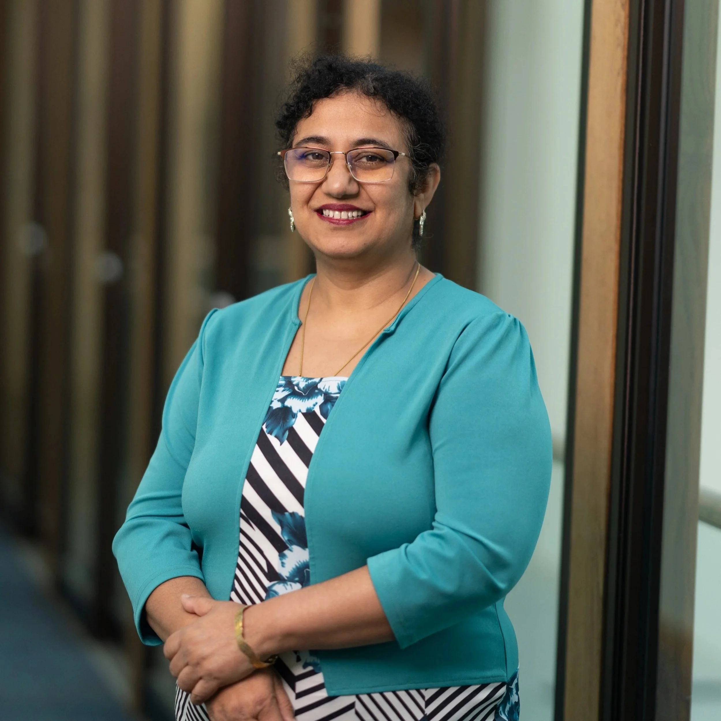 HSNS board member, Dr. Kaur, smiling at camera in a hallway