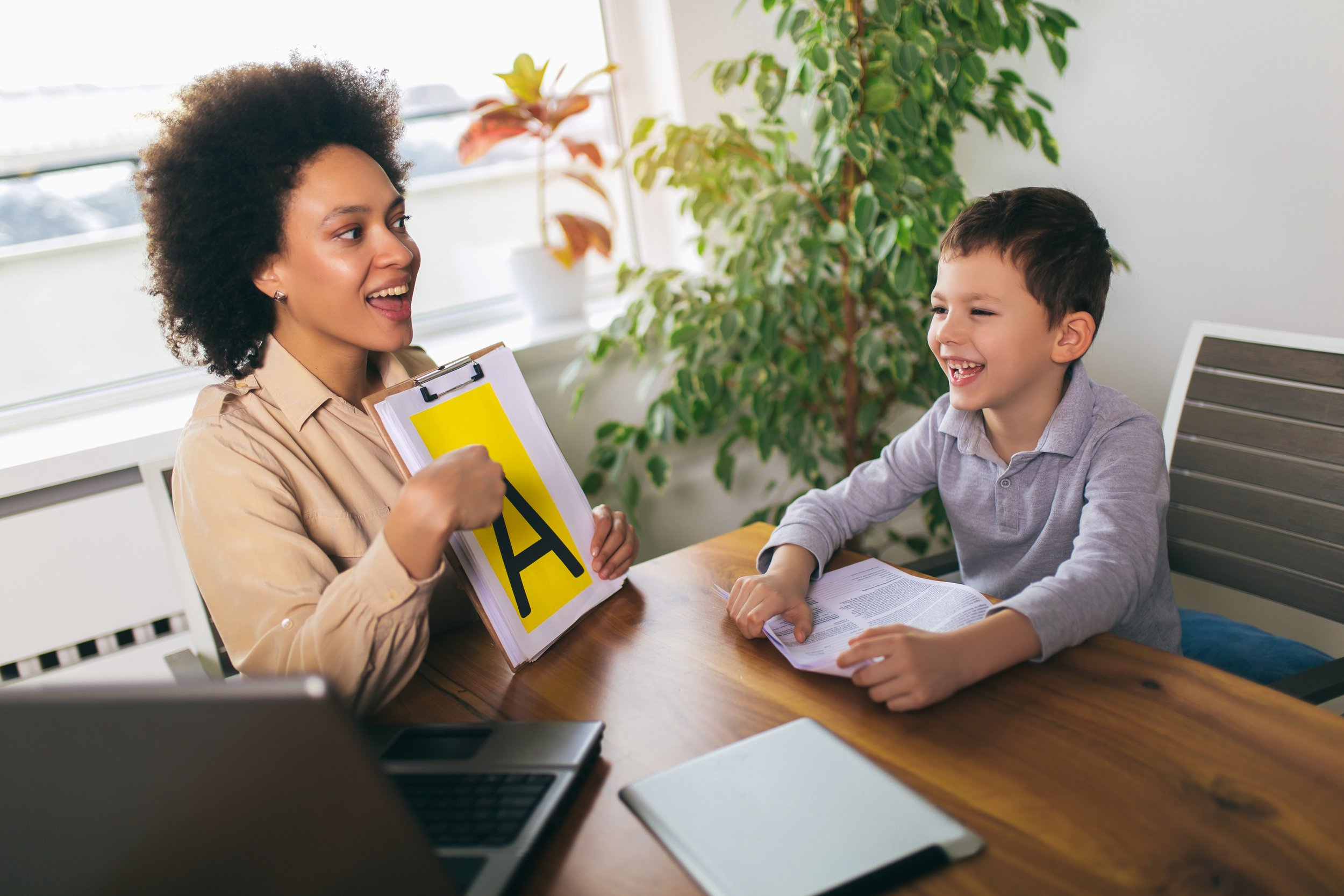 Speech Language Pathologist pointing to the letter A with a child client
