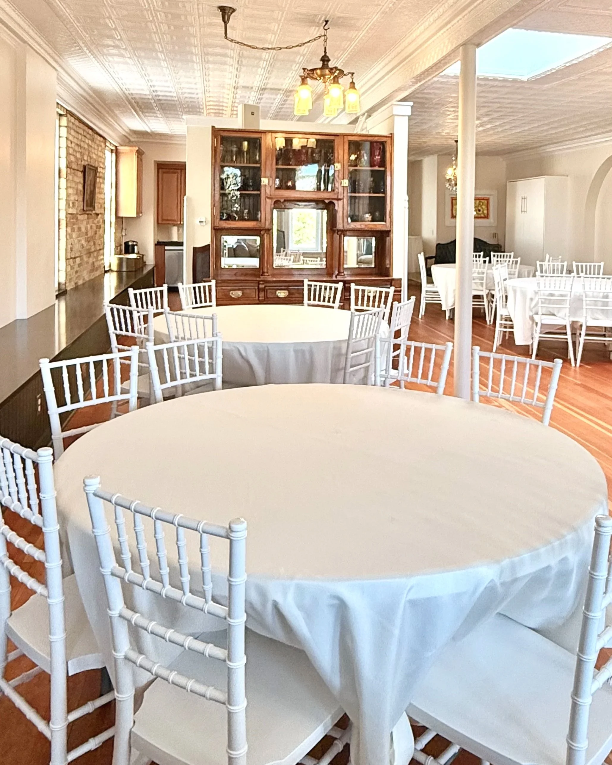 Upstairs events seat up to 56 guests. Seven 
 5' round tables and white Chiavari chairs, are included with your rental. If necessary add'l seating is available with mismatched antique oak chairs and smaller coordinating round tables.