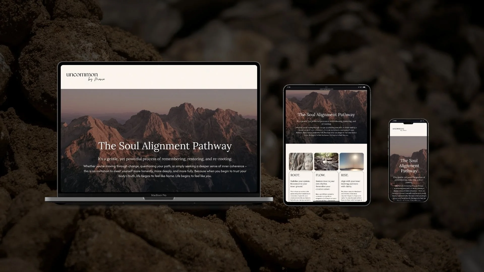Three electronic devices displaying a web page titled "The Soul Alignment Pathway" on a rocky surface, with a mountain landscape background.