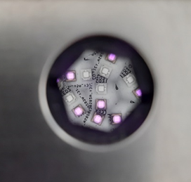 Top view of the Paios LED array as seen through the light mixing rod aperture, showing multiple illuminated LEDs arranged around the central optical axis.