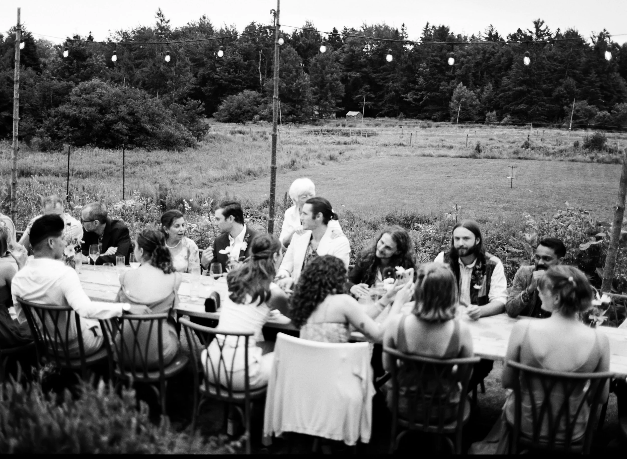 garden party wedding in maine with guests talking and laughing candidly