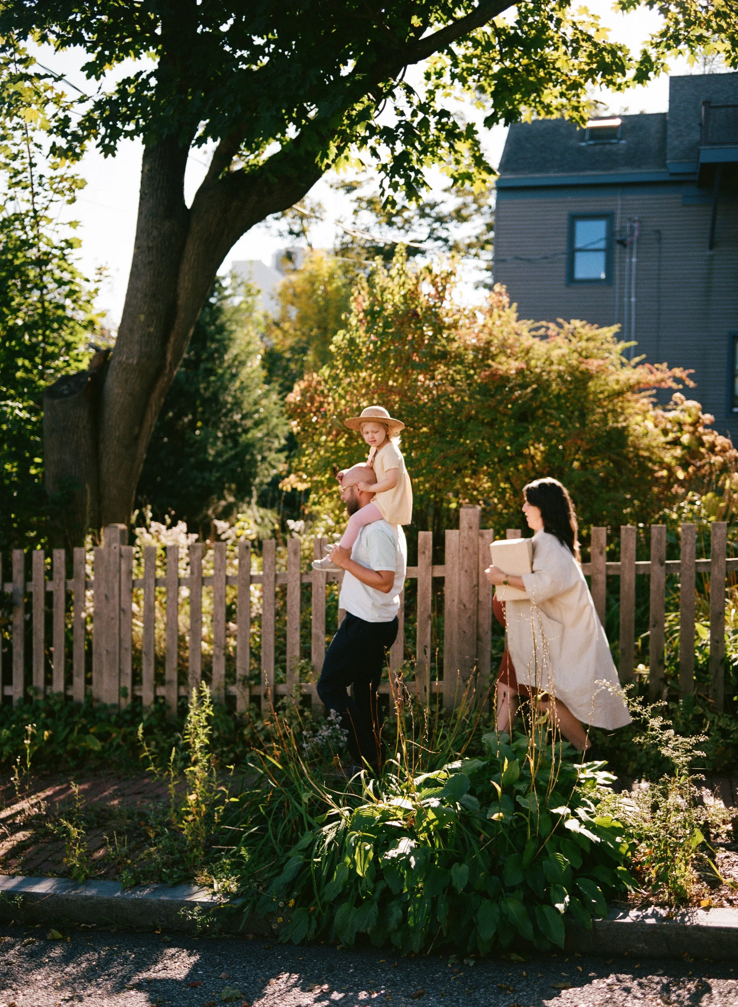 A family walks their neighborhood in portland maine during a documentary family maternity photography session