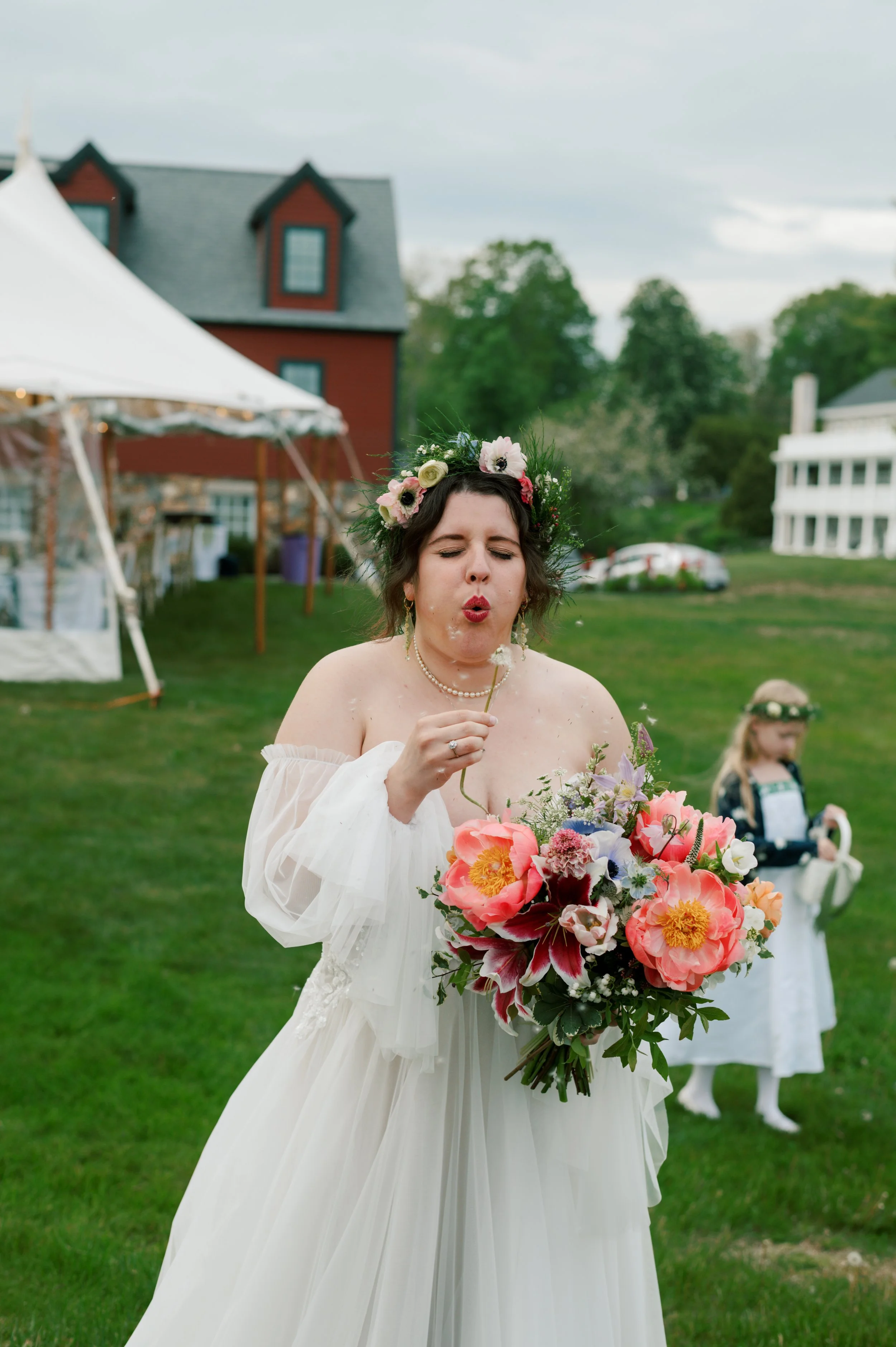 A bride blows a dandelion before her ceremony in kittery maine