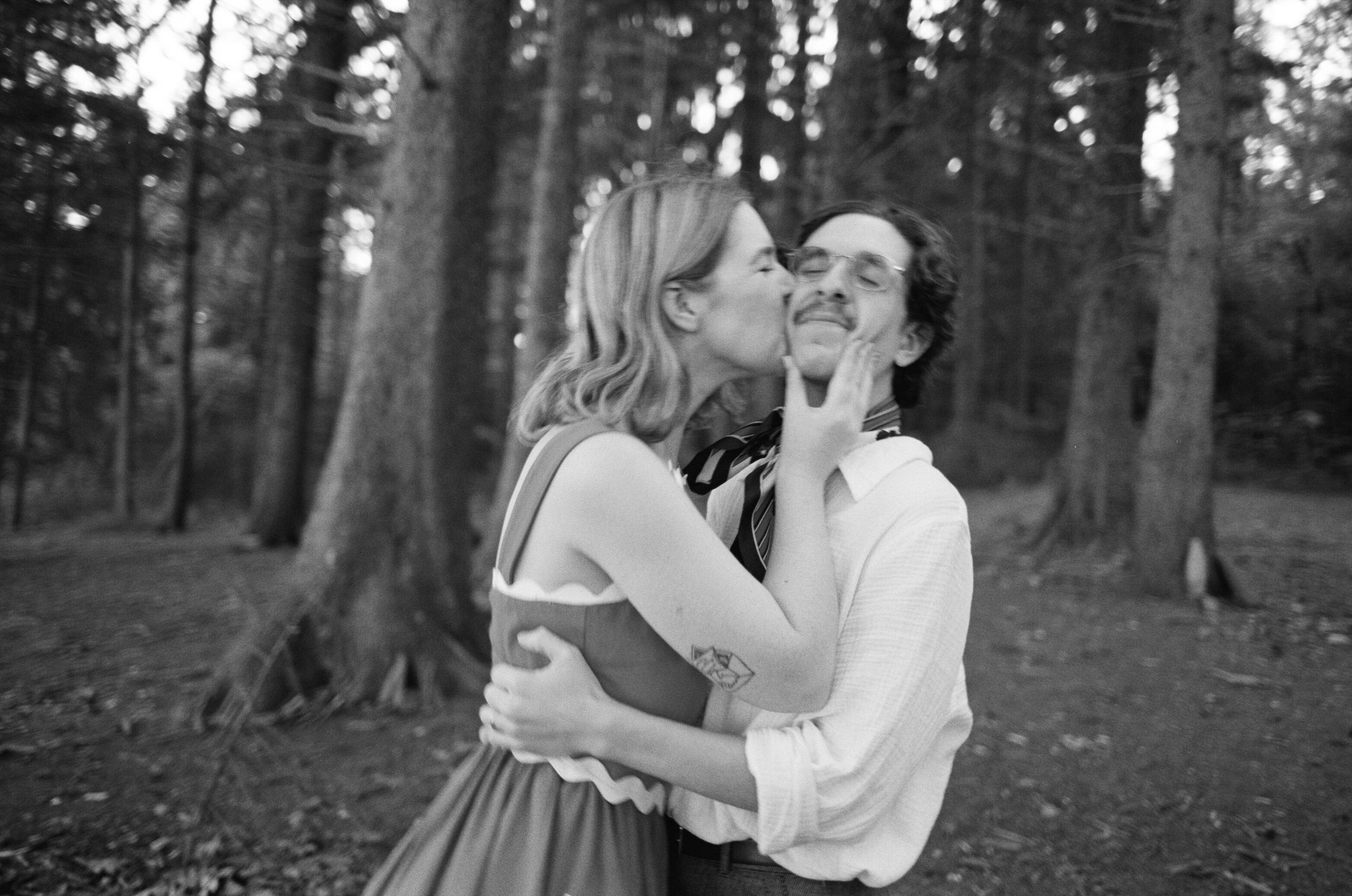 a couple kissing in a wooded city park