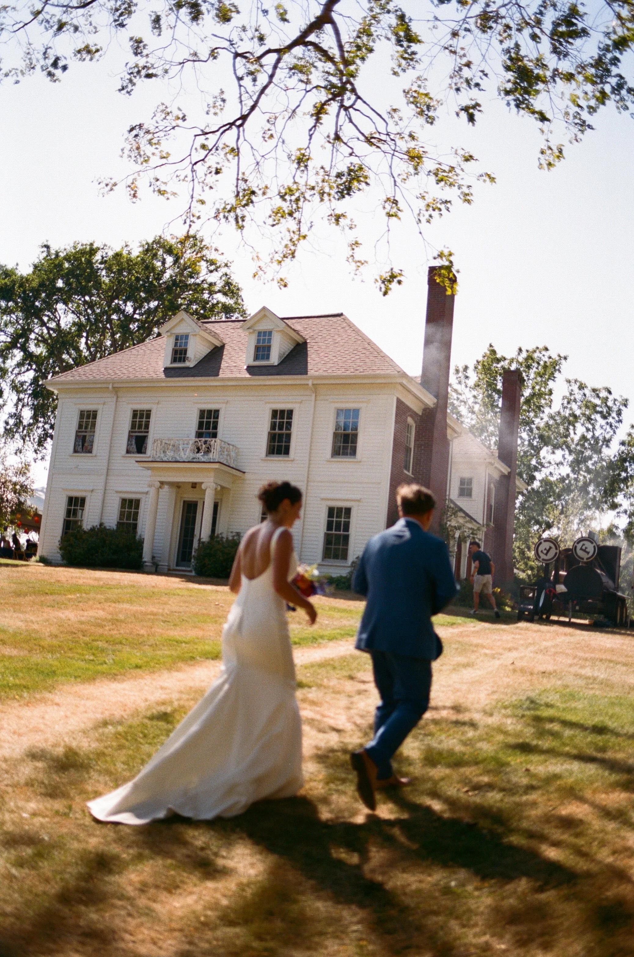 couple walks outside home at backyard wedding in midcoast maine on film