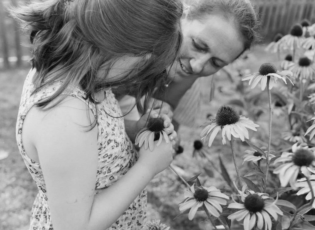 Smelling coneflowers in maine during photo session