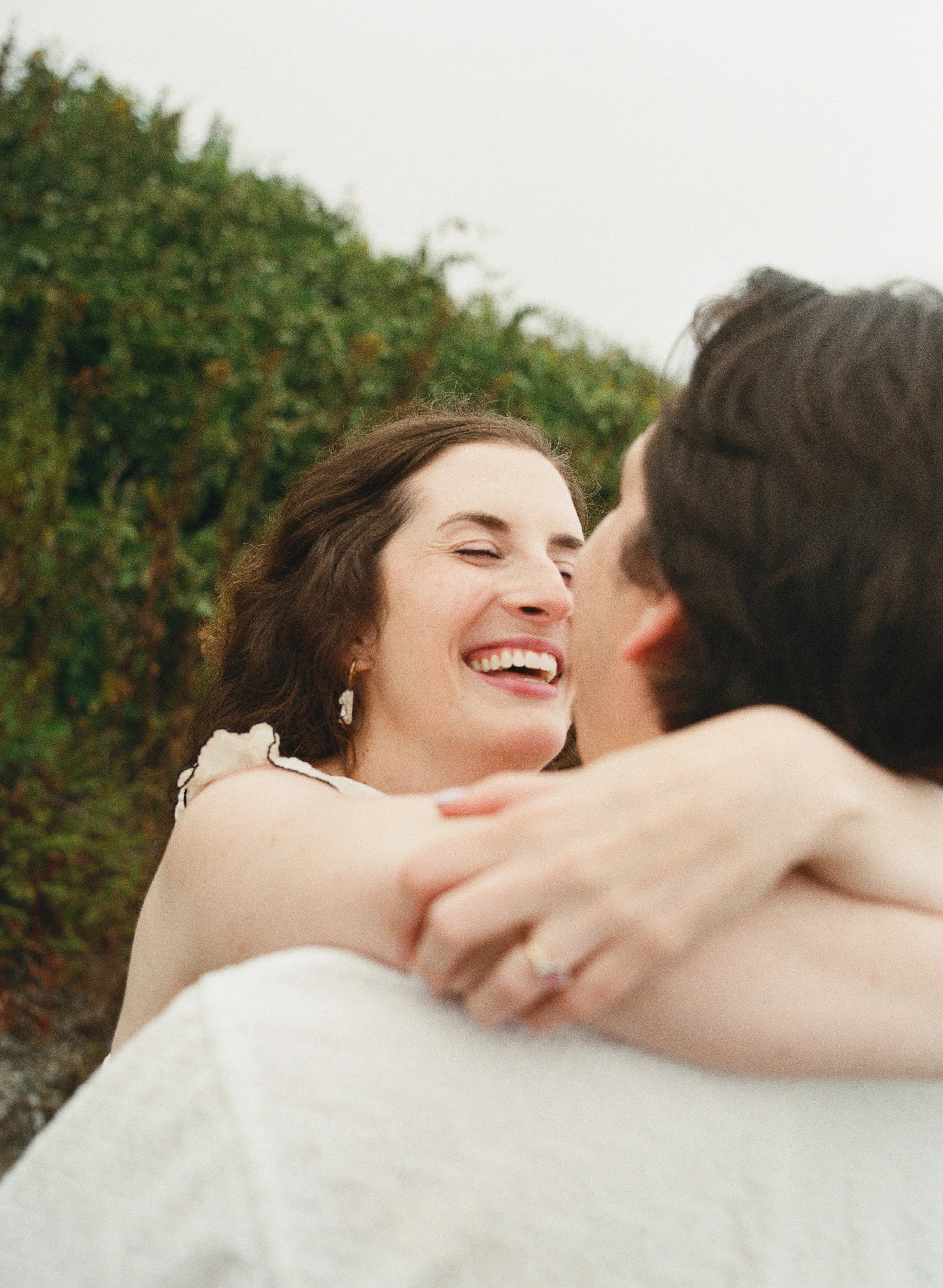 a women smiling at her fiance at a park in cape elizabeth maine