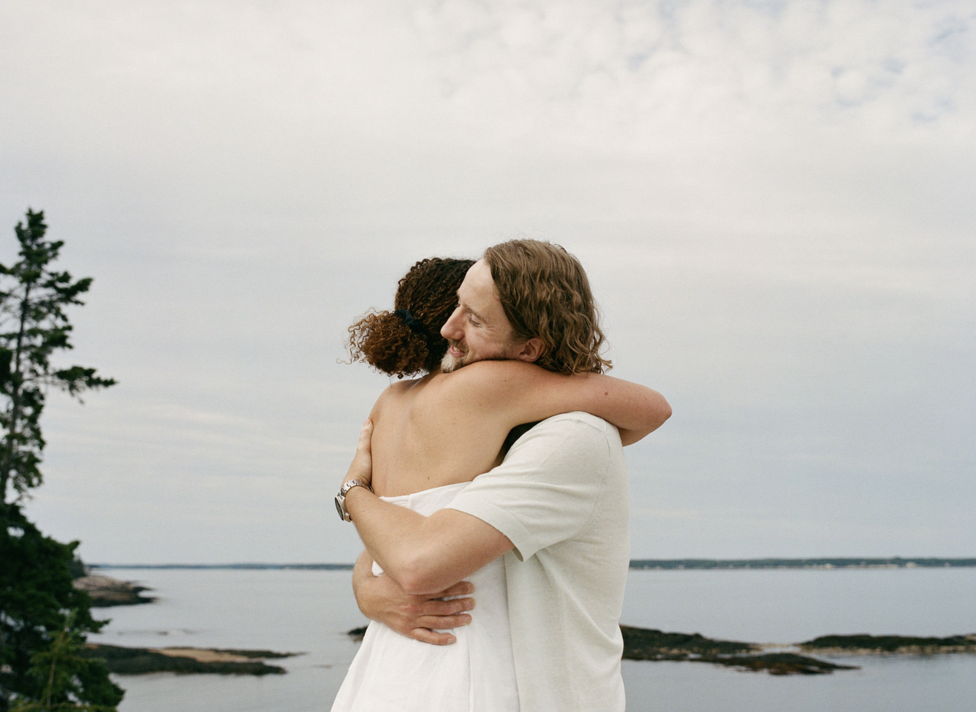 a couple hugging during maine beach engagement session on film