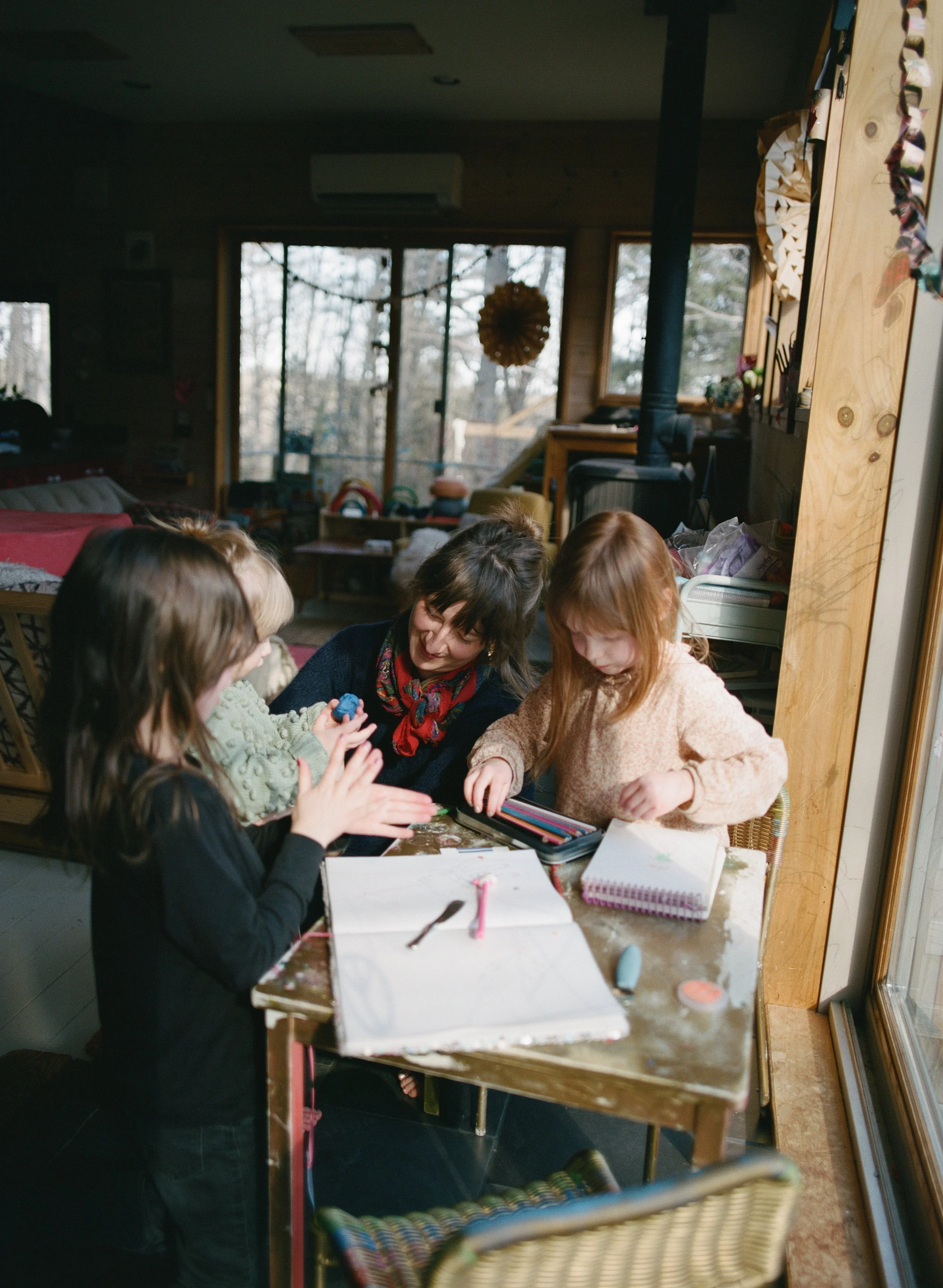 a mother helps her three daughters with arts and crafts during family photo session