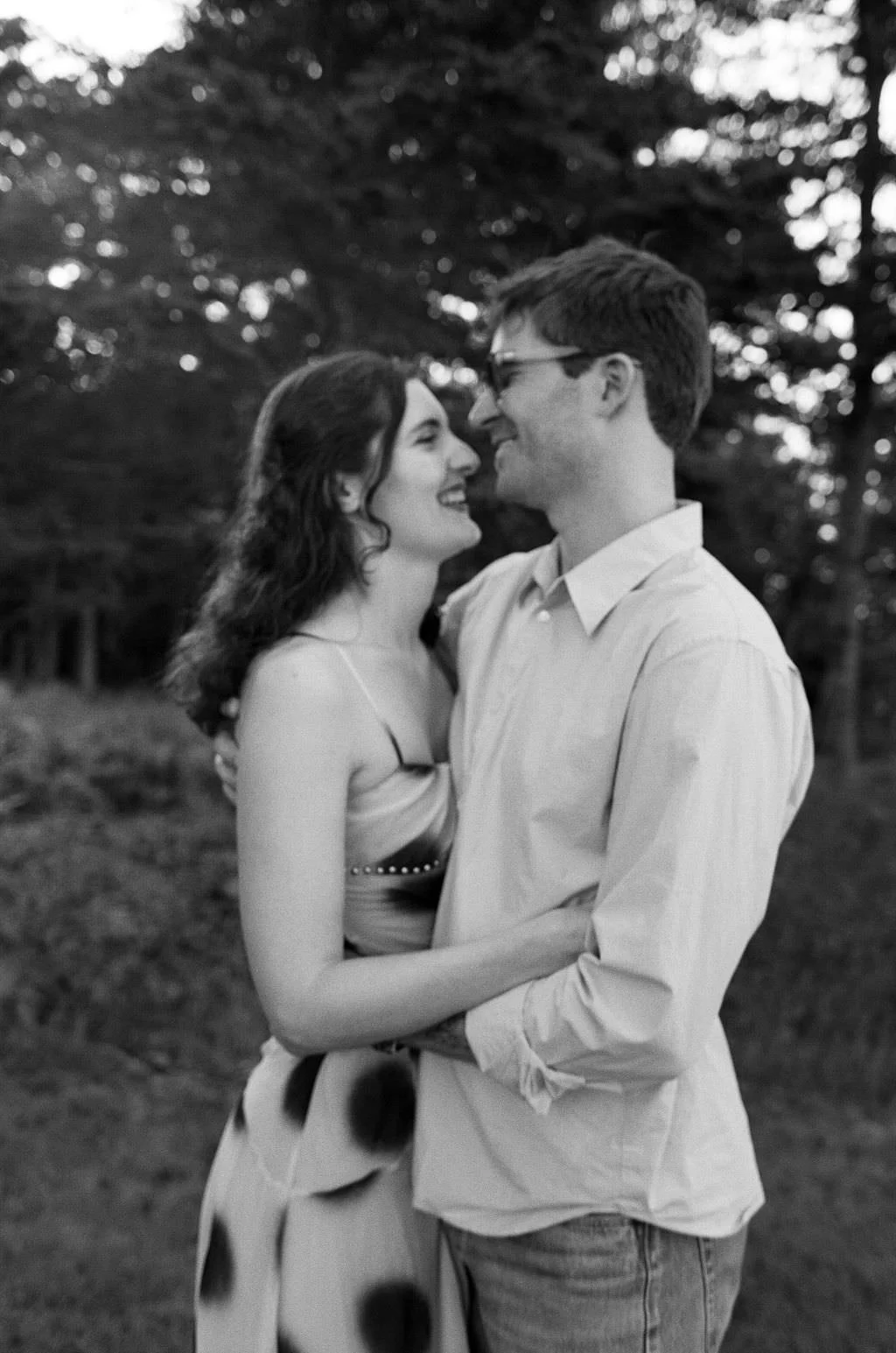 a man and a woman looking at each other during sunset engagement session in maine