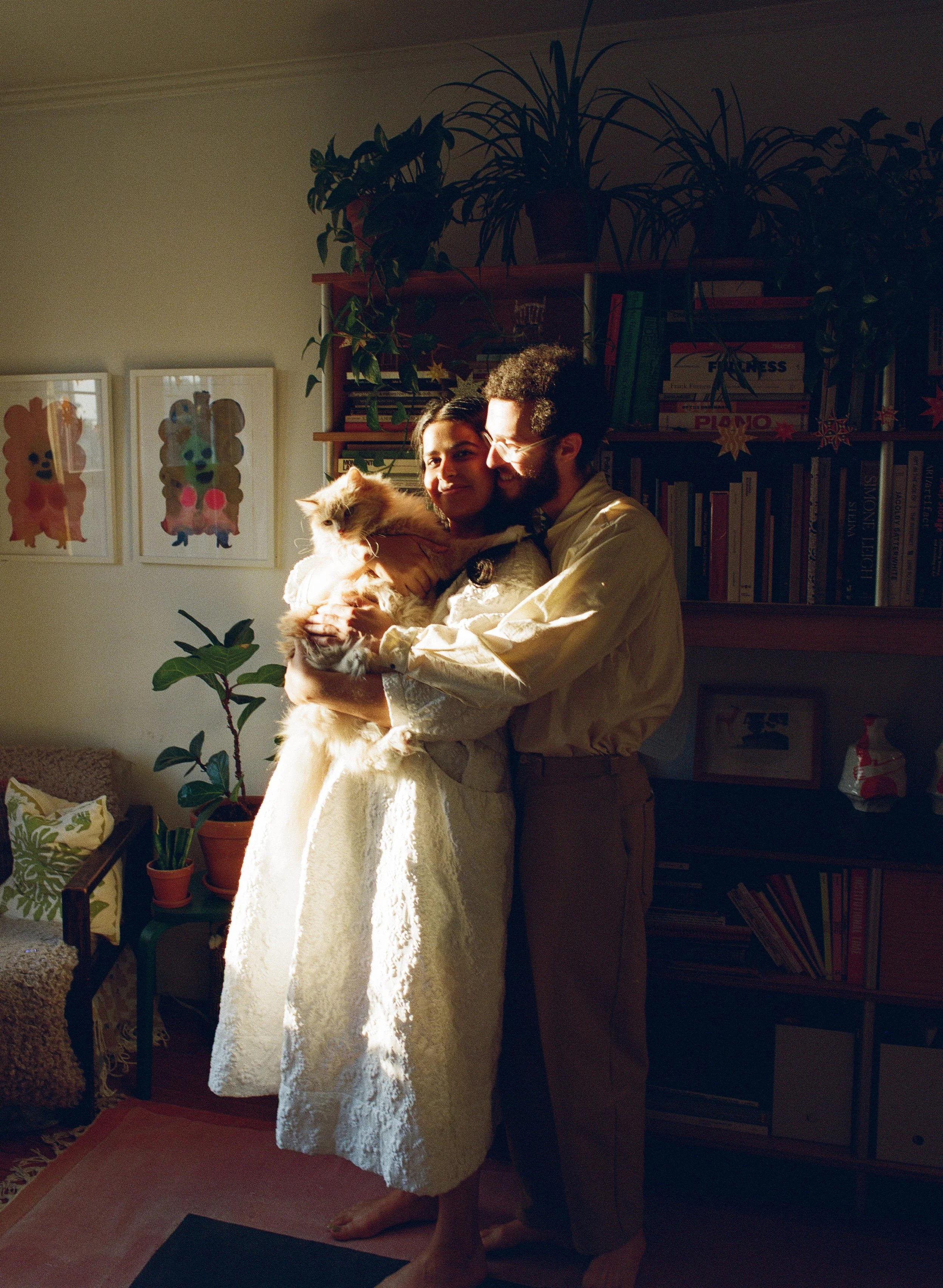 A couple holding their cat in their boston apartment on film