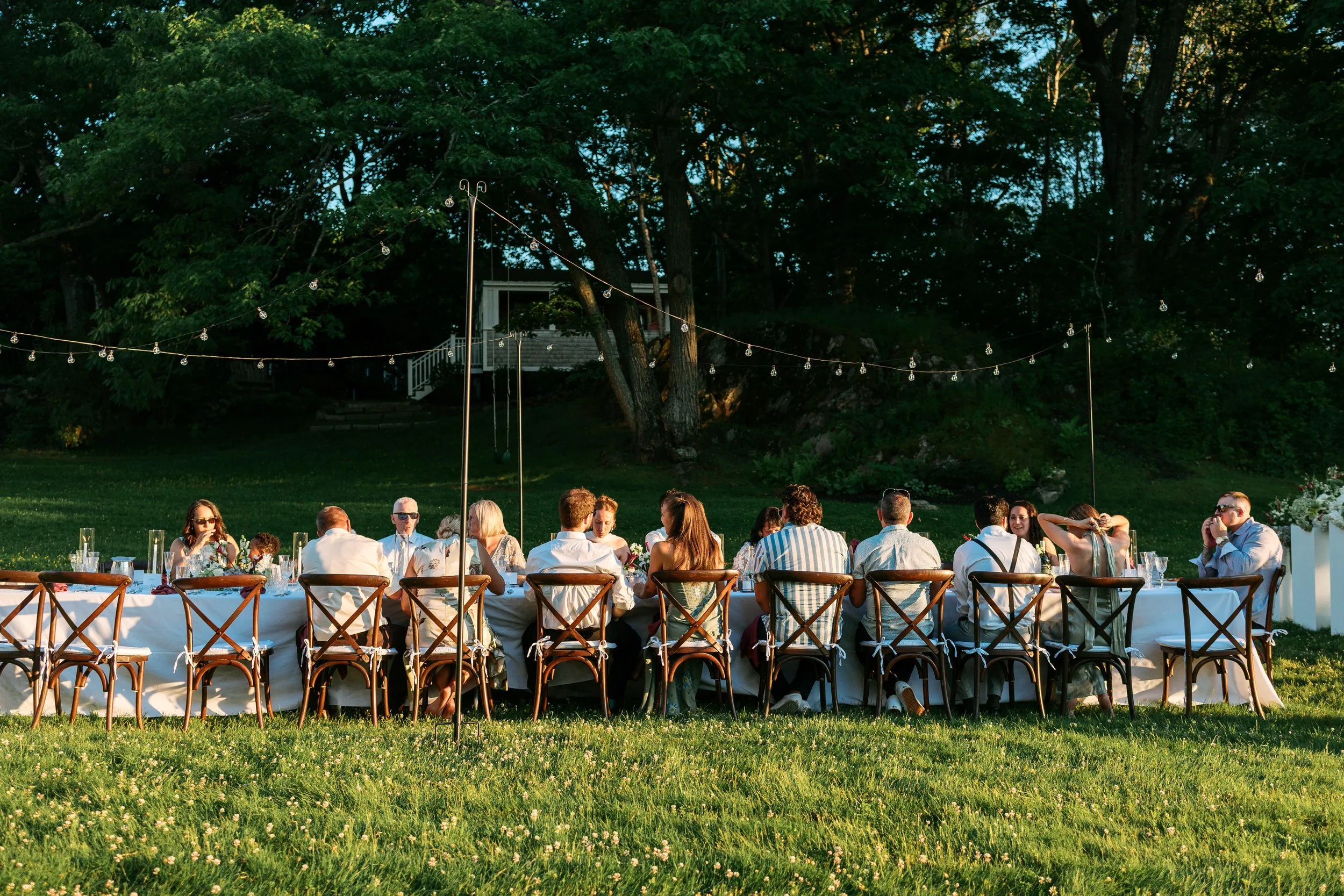 guests gathering for outdoor dinner at sunset in kennebunkport maine