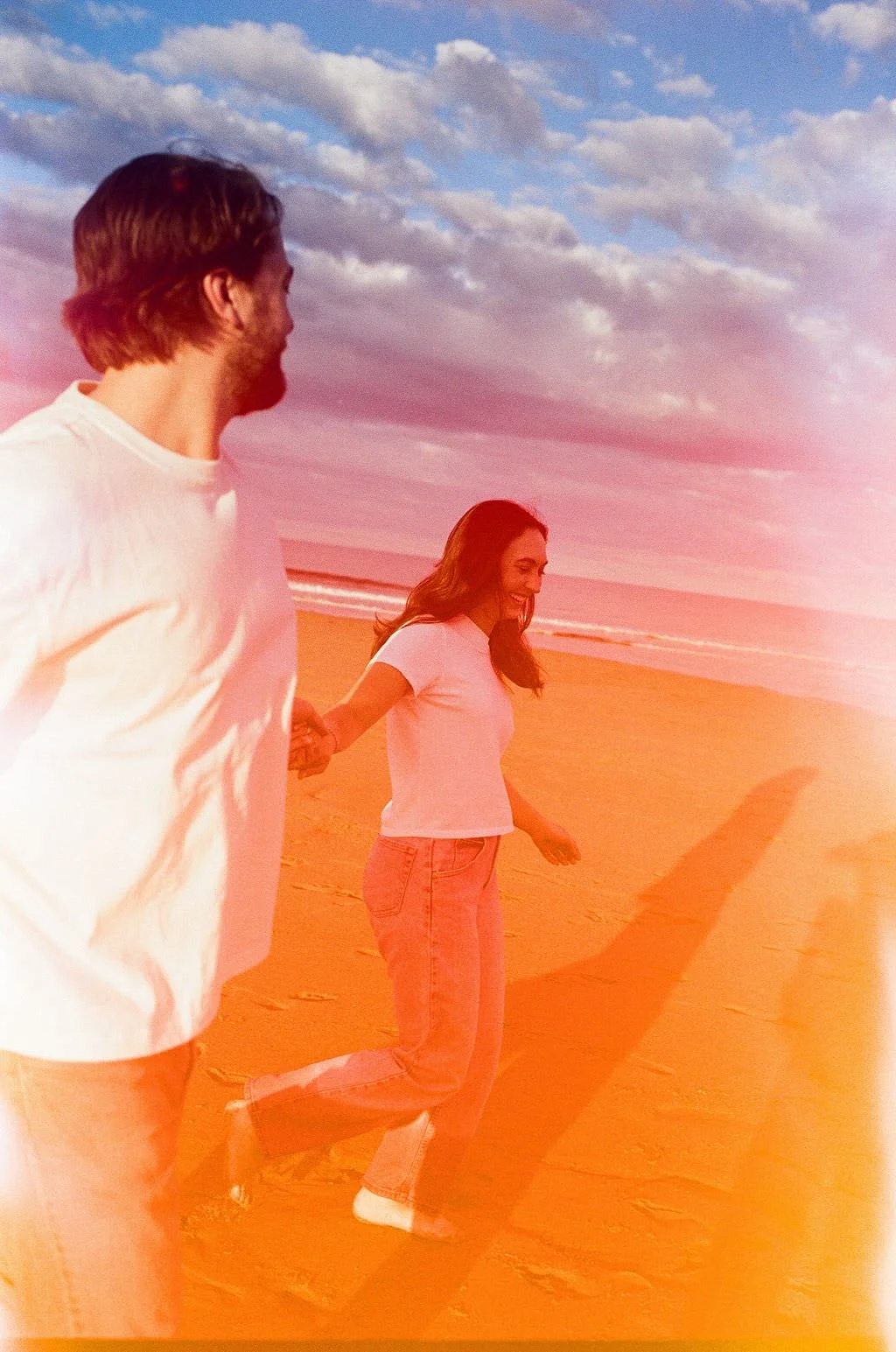 candid of a couple laughing on the beach in southern maine on film