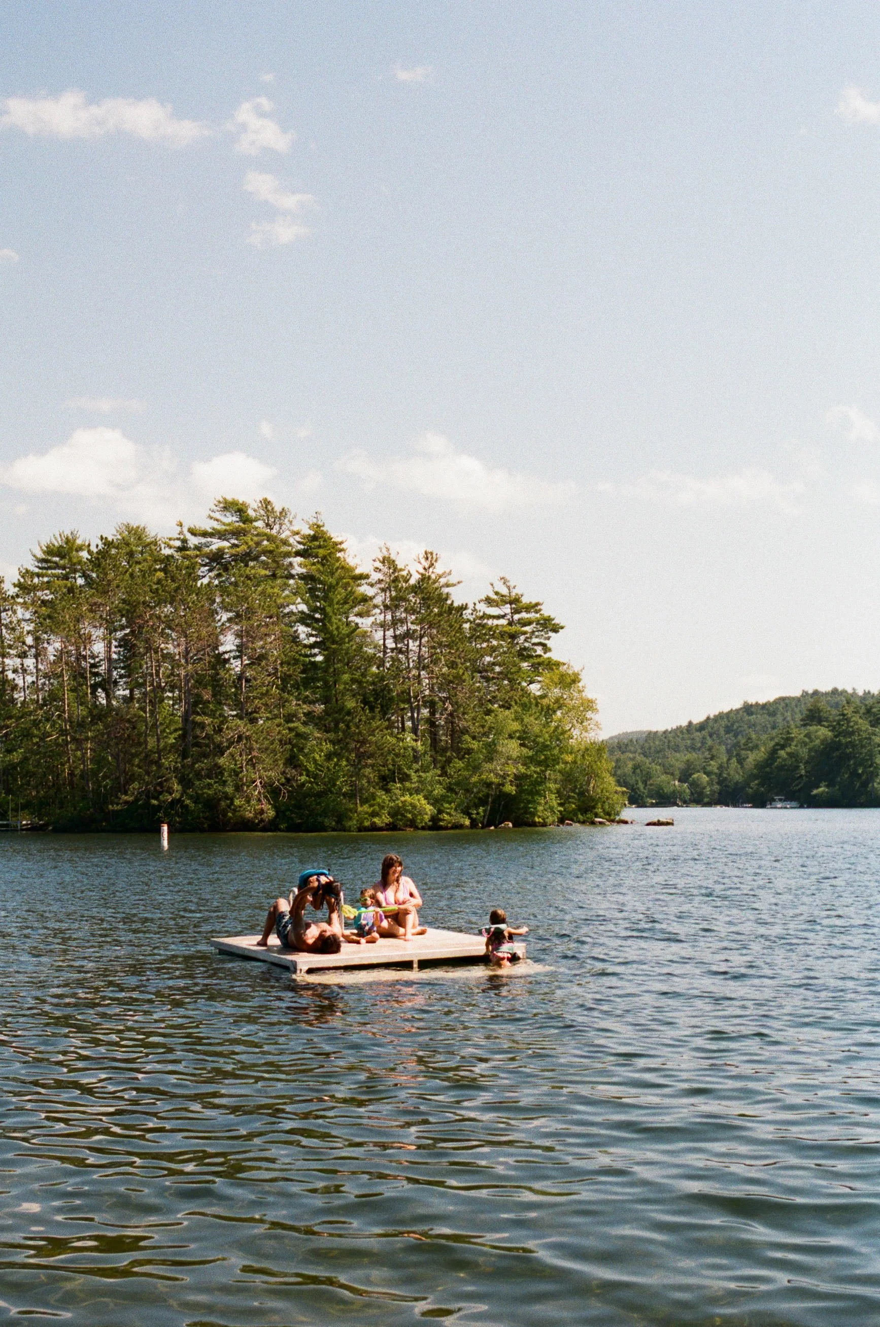 New Hampshire documentary family photography on analog film of family swimming on dock