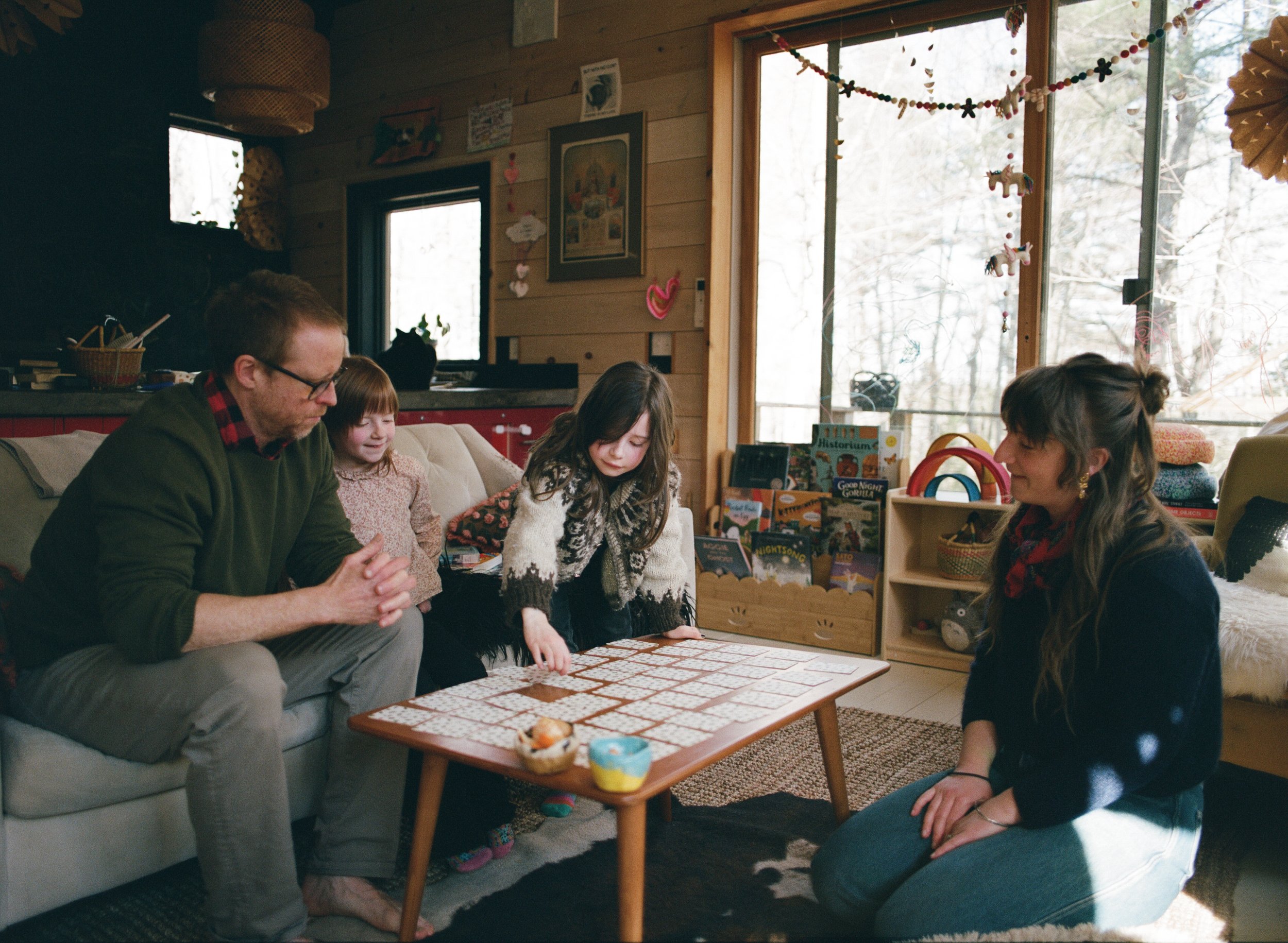 a family plays a game of memory at home during family photo session