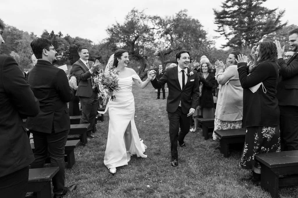 couple exits after ceremony at tops'l farm in midcoast maine on black and white film