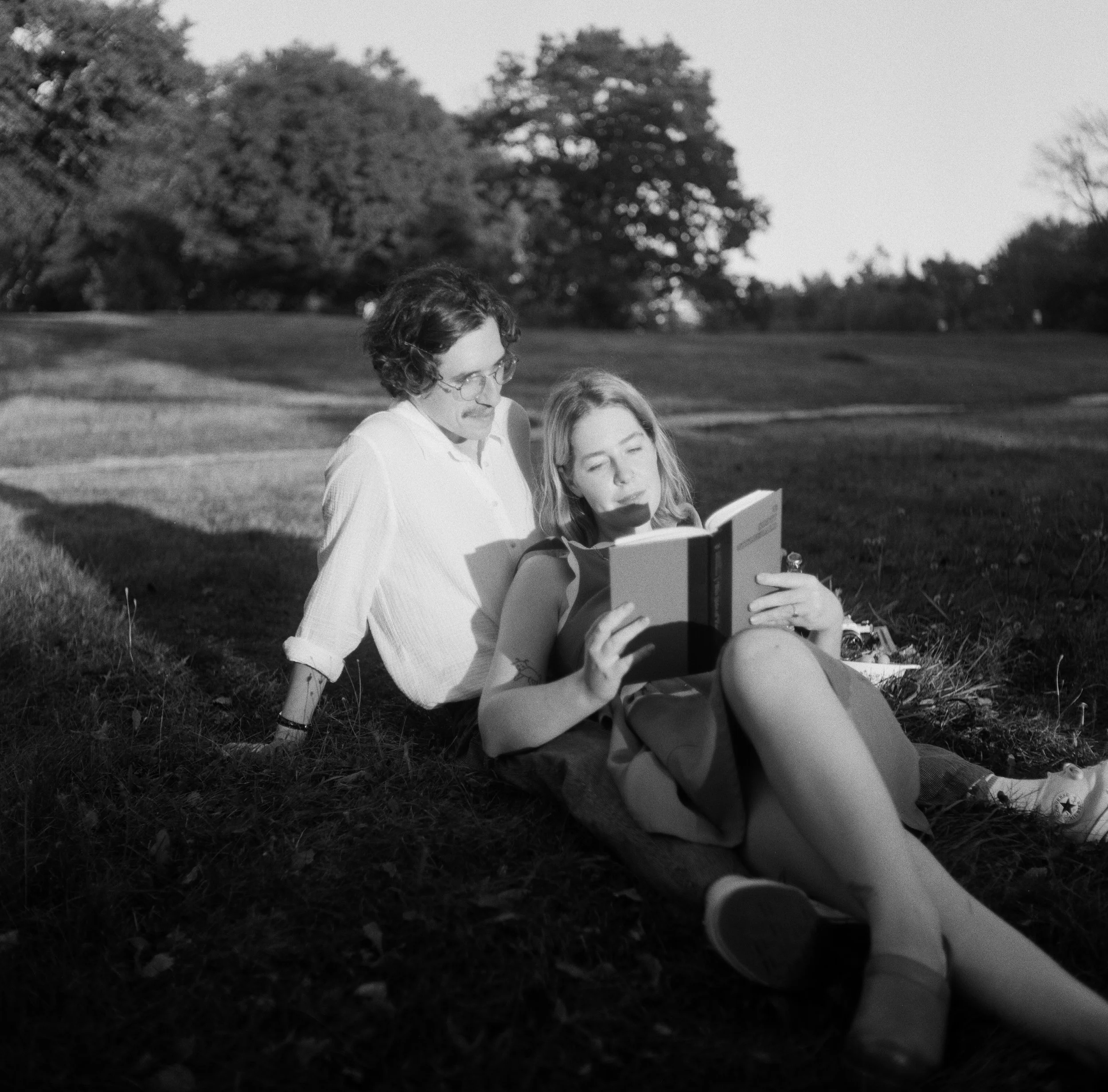 a couple reading at the park in portland maine