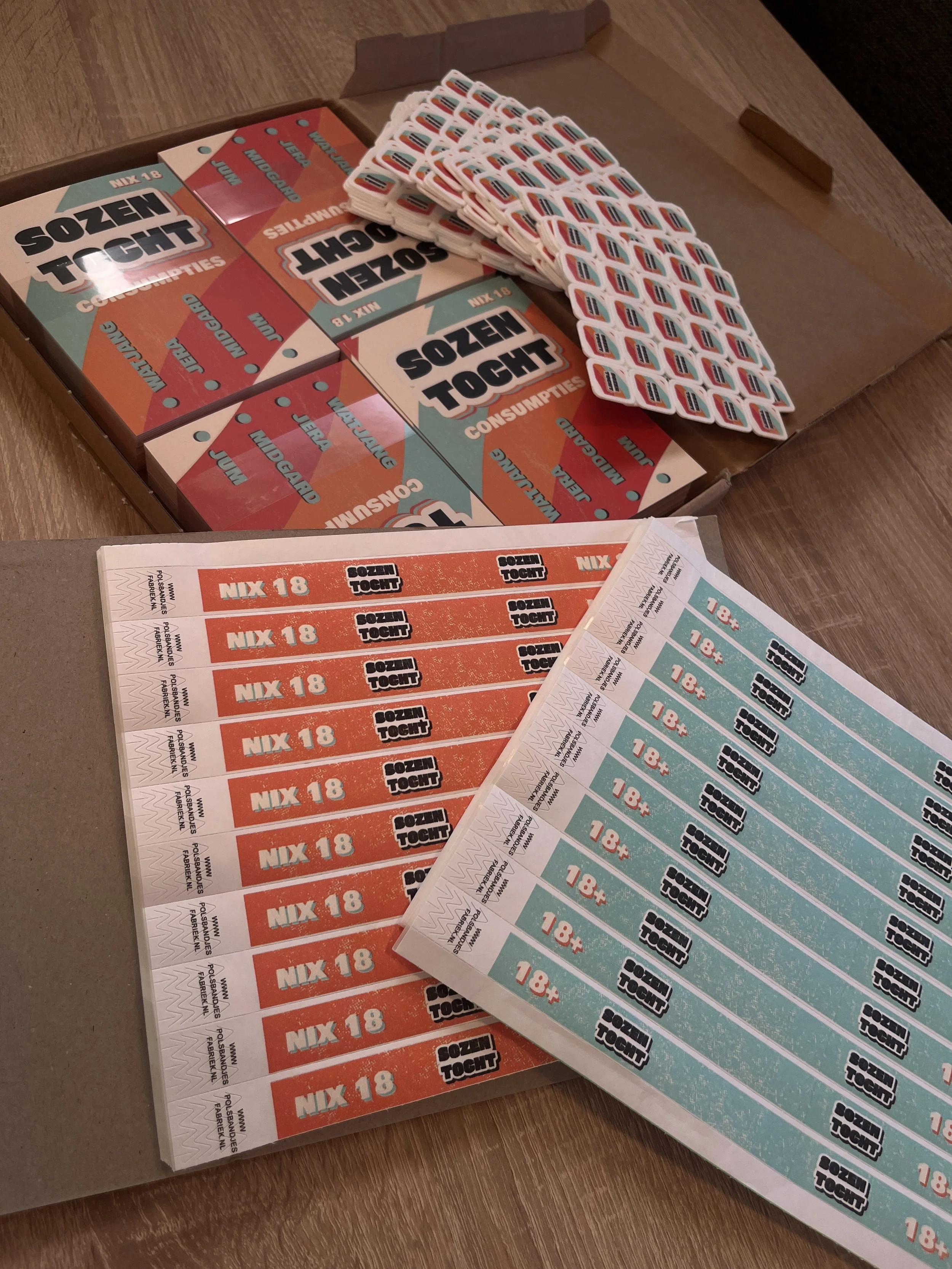 Een doos met kaartjes voor een geheugenspel genaamd 'Sozen Tought', met kleurrijke instructiekaartjes en stickers op een houten tafel.