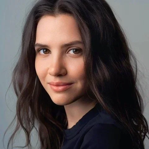 A young woman with long brown hair and a slight smile, looking directly at the camera.