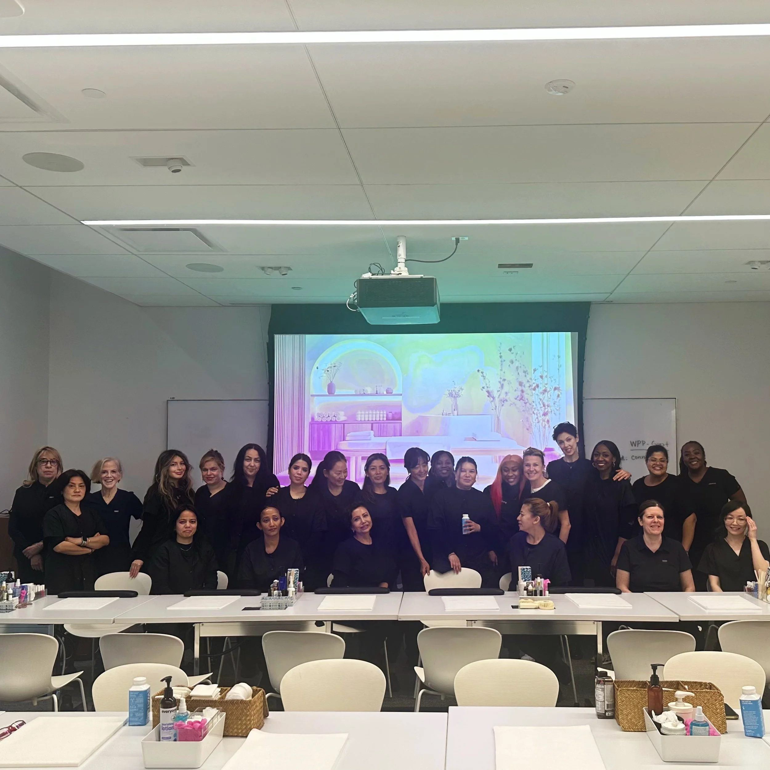 Group of women in a classroom or conference room posing for a photo.