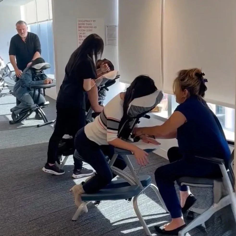 Primp Events team members offering on-site chair massages to employees in a New York City office setting.