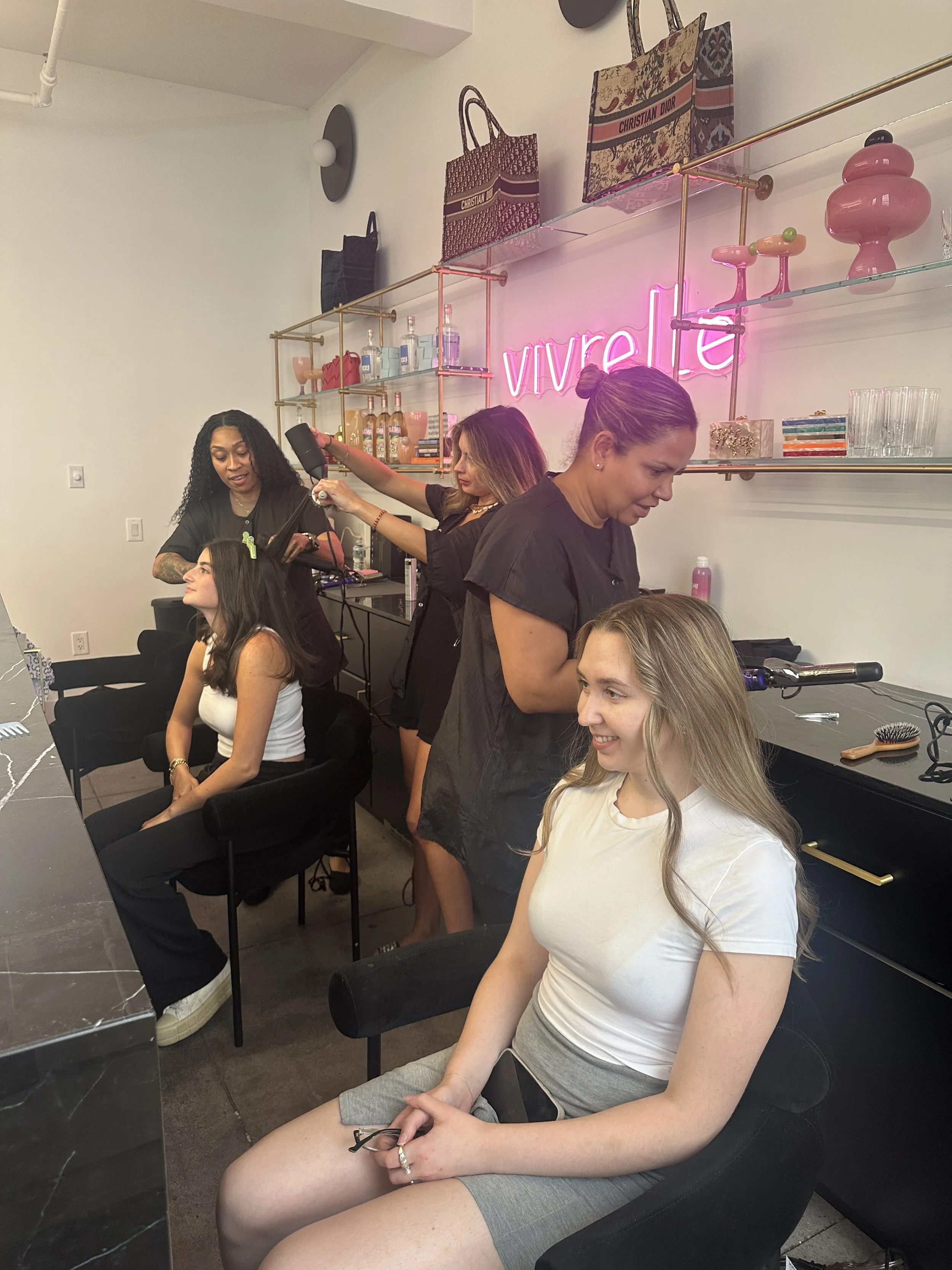 At a Vivrelle event, Primp Events hairstylists style guests’ hair in a sleek office filled with natural light and modern details.