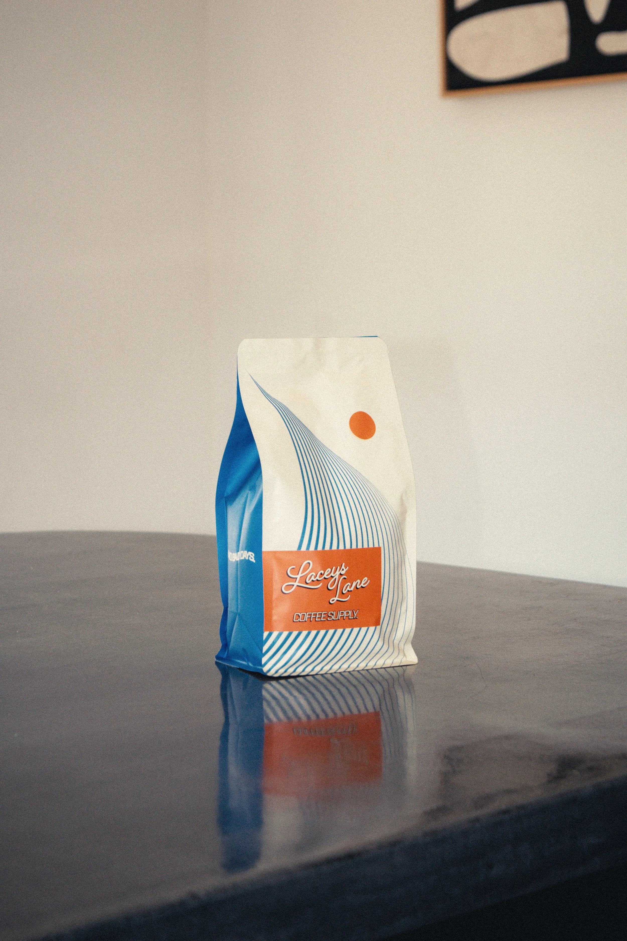 Bag of Laceys Lane coffee supply coffee beans on a reflective countertop