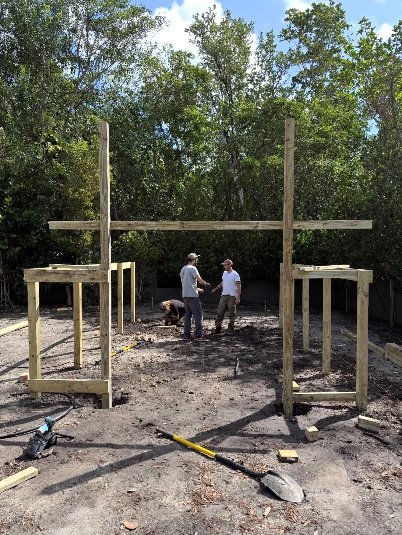 Crew setting the wooden posts for the iguana enclosure during construction of the Pinecrest kitchen garden