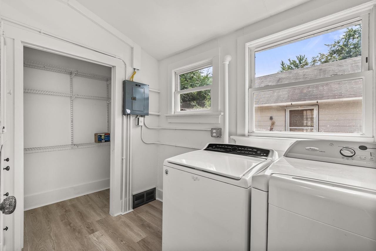 Laundry room with washing machine, dryer, and utility closet with wire shelves.