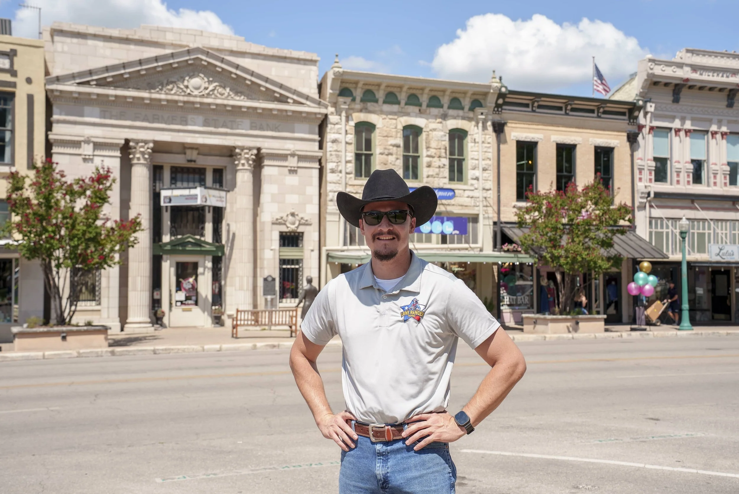 Julio Rojas, owner of Lone Ranger Roofing, standing in front of historic downtown Georgetown, TX near the Farmers State Bank building.