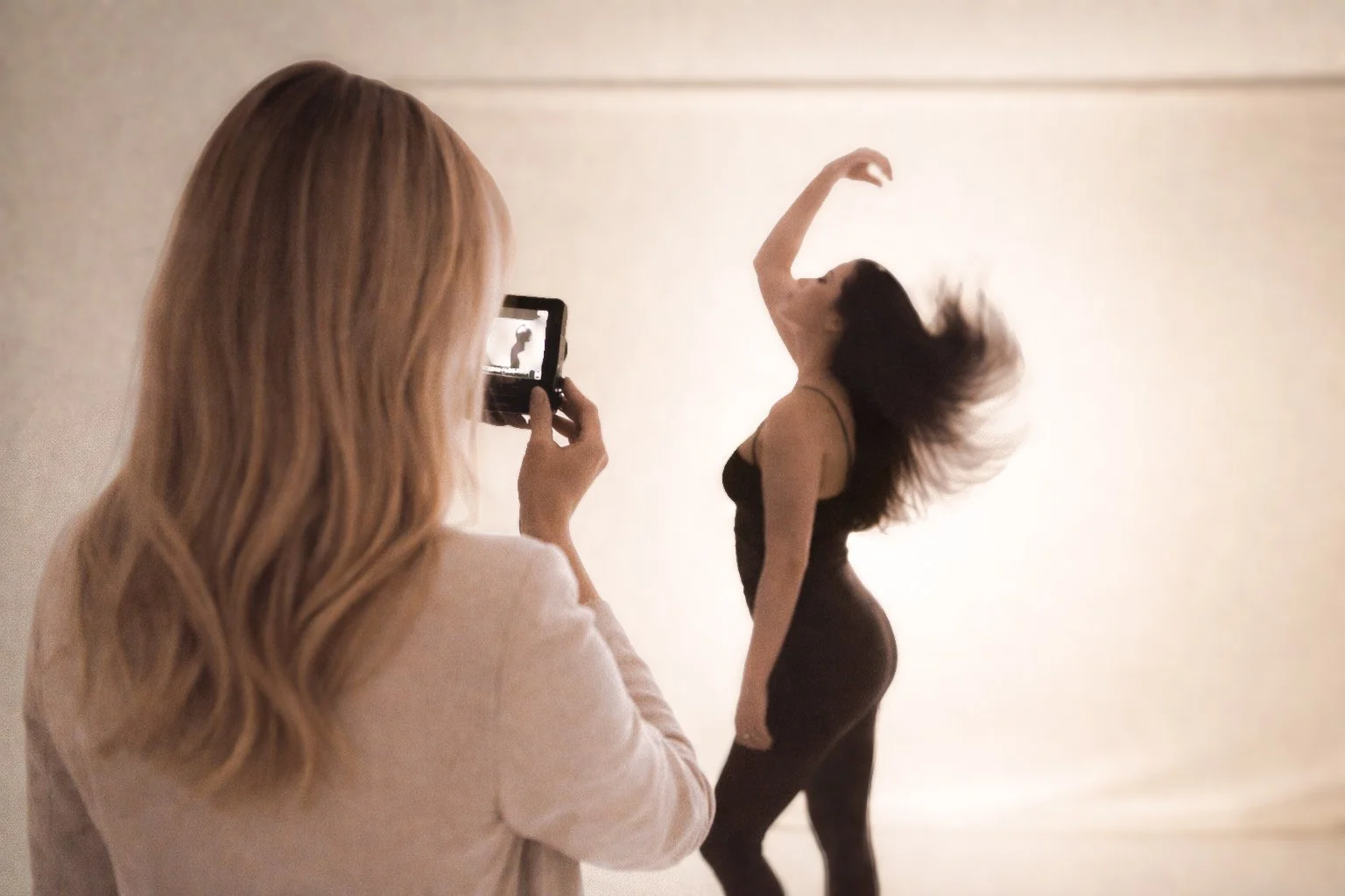 Professional photoshoot: woman taking photos of another woman posing