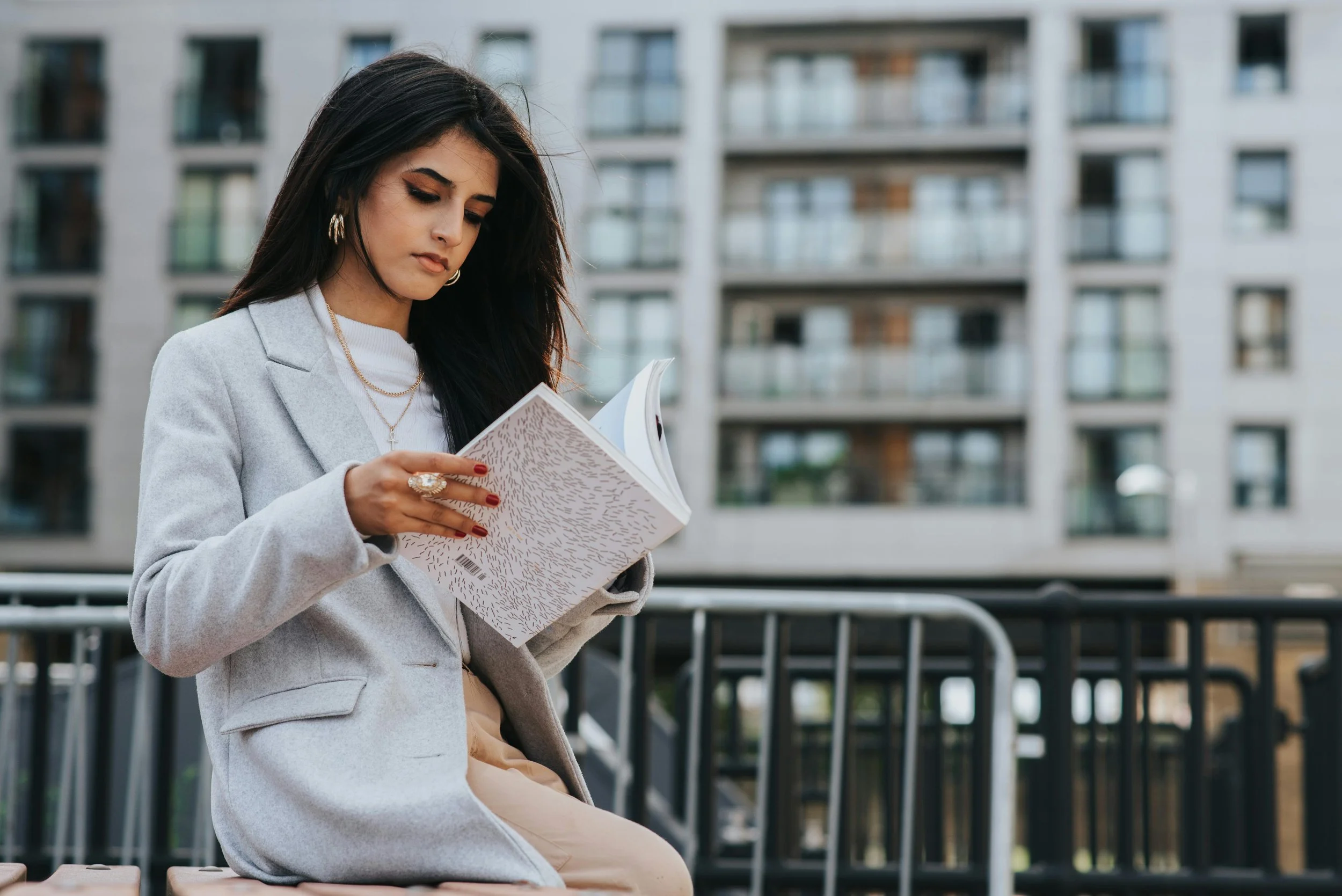 Woman standing outside thumbing through a book, representing curiosity and growth through online therapy for high-achieving adults in Northern Virginia
