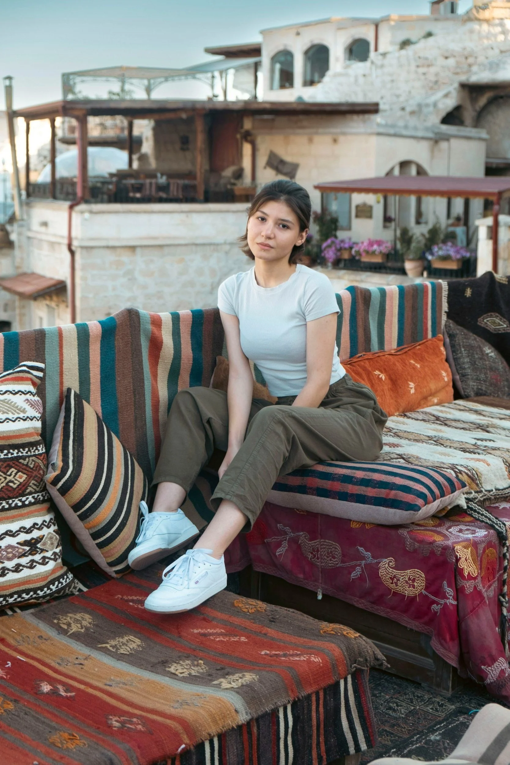 Woman sitting outside on a couch surrounded by cushions, representing the tension between personal space and family expectations in cultural identity therapy in Virginia