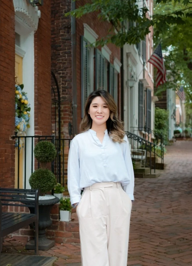 Anabelle Hwang, licensed trauma and anxiety therapist at Blooming Days Therapy, standing outside and smiling in Northern Virginia