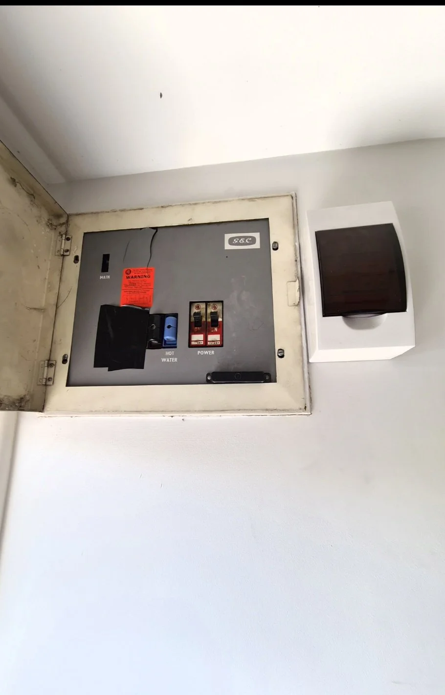 Before photo of basic, old residential switchboard