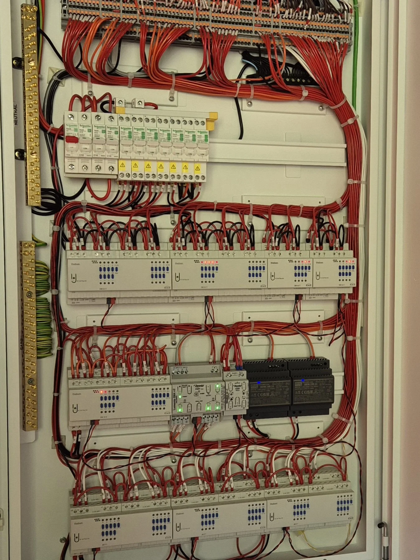 Wiring inside plastered in hidden switchboard with actuators for KNX lighting control.