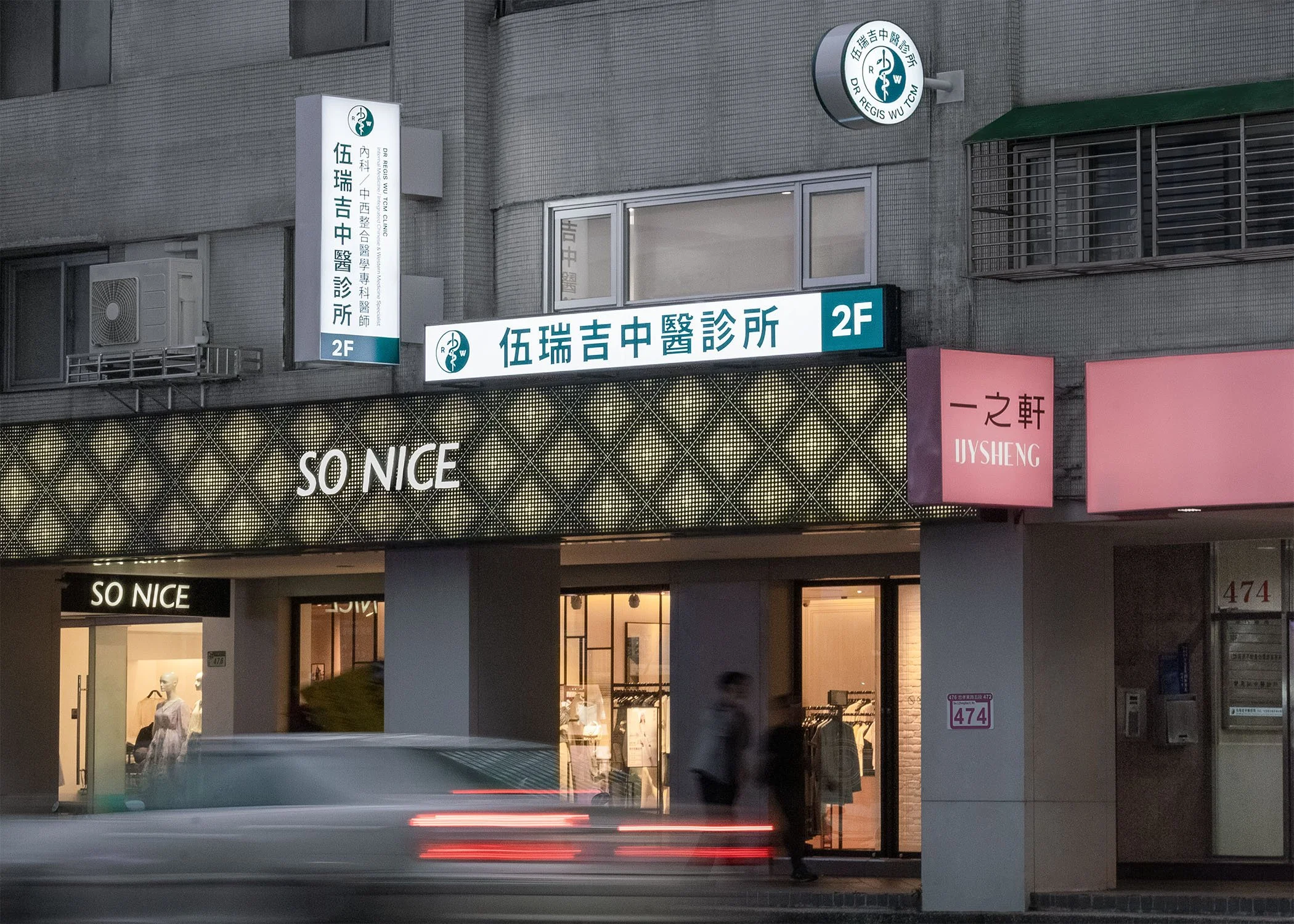 夜晚的市區商業街道，中醫診所招牌清楚發光，門面醒目，方便晚間就診民眾辨識位置。