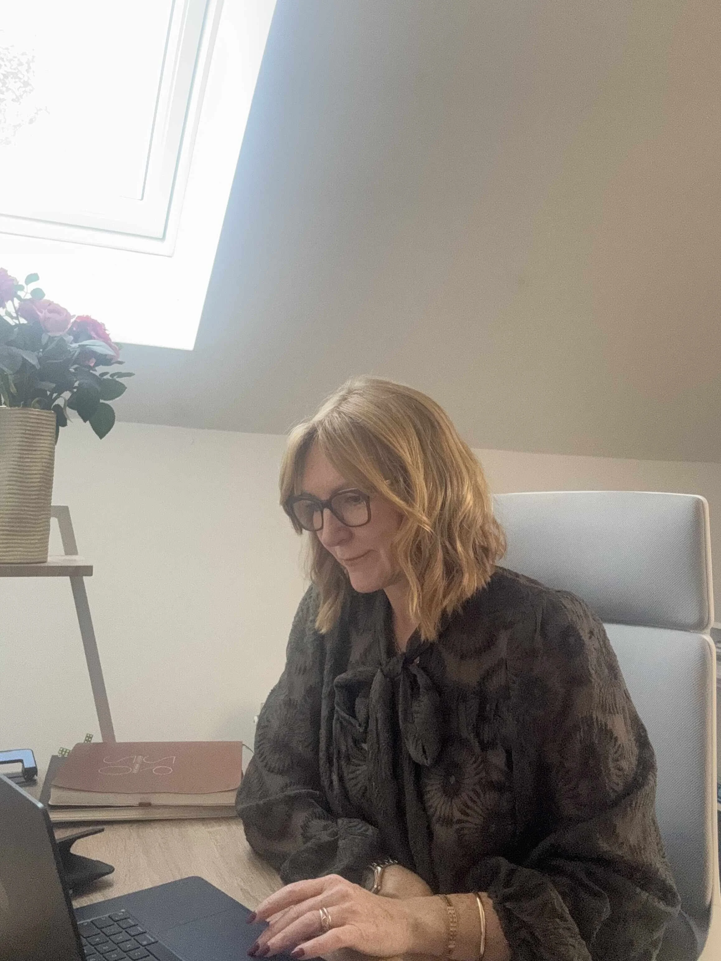 Lindsey Whitaker working at a laptop in a bright home office, reflecting the self‑study programme’s flexible, structured support for midlife women navigating perimenopause at their own pace.