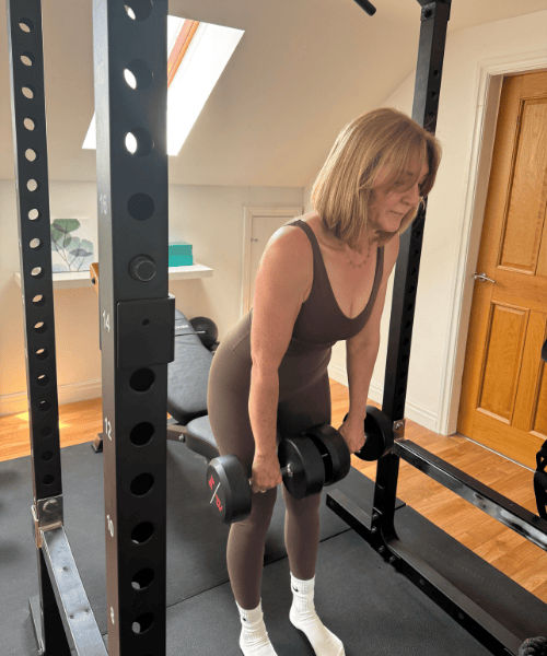 Lindsey Whitaker strength training in a home gym, reflecting the Midlife Rebalance Circle’s empowering approach to movement and midlife health.